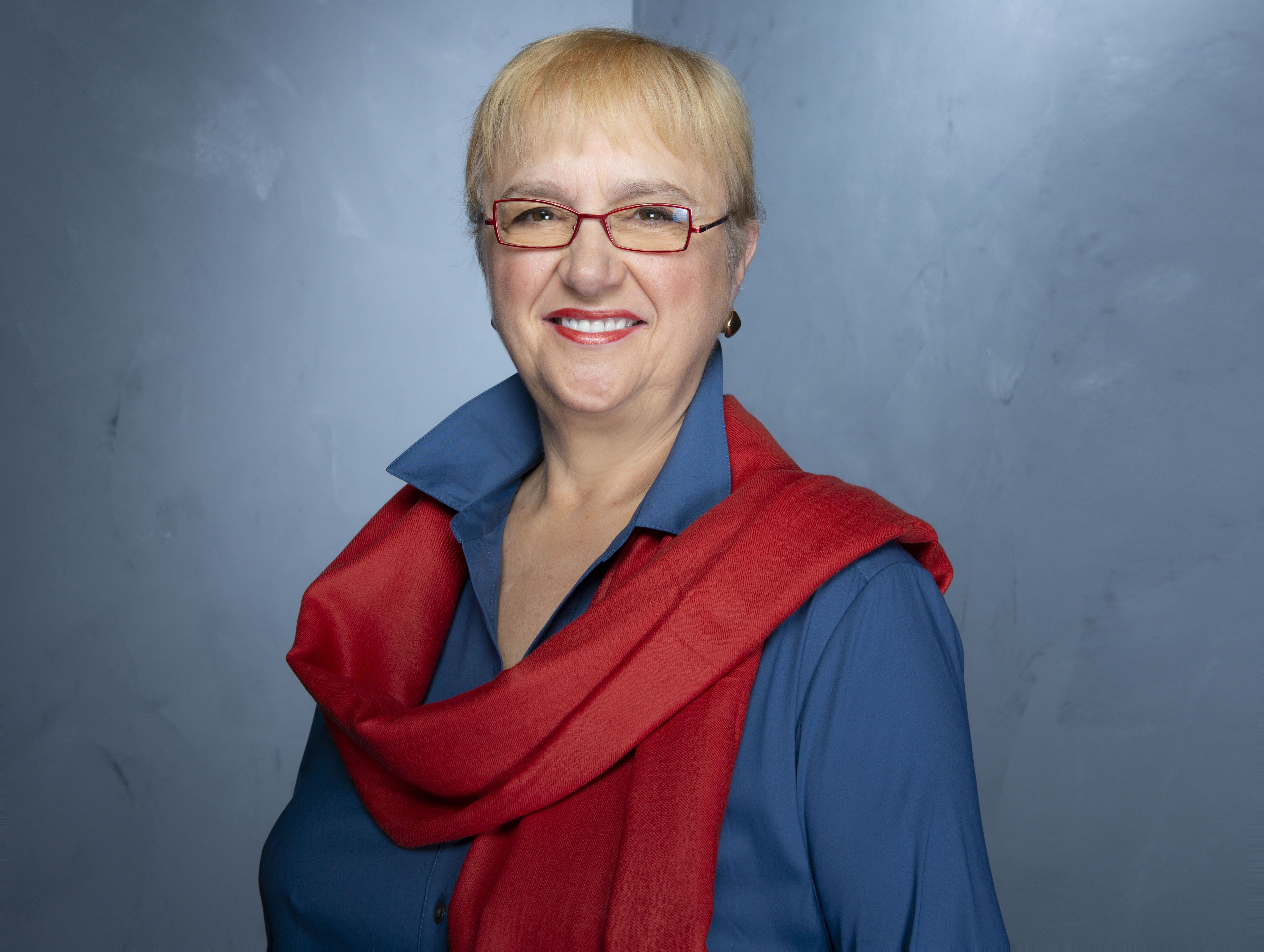 Celebrity chef Lidia Bastianich wears a blue top and red scarf in this photograph.