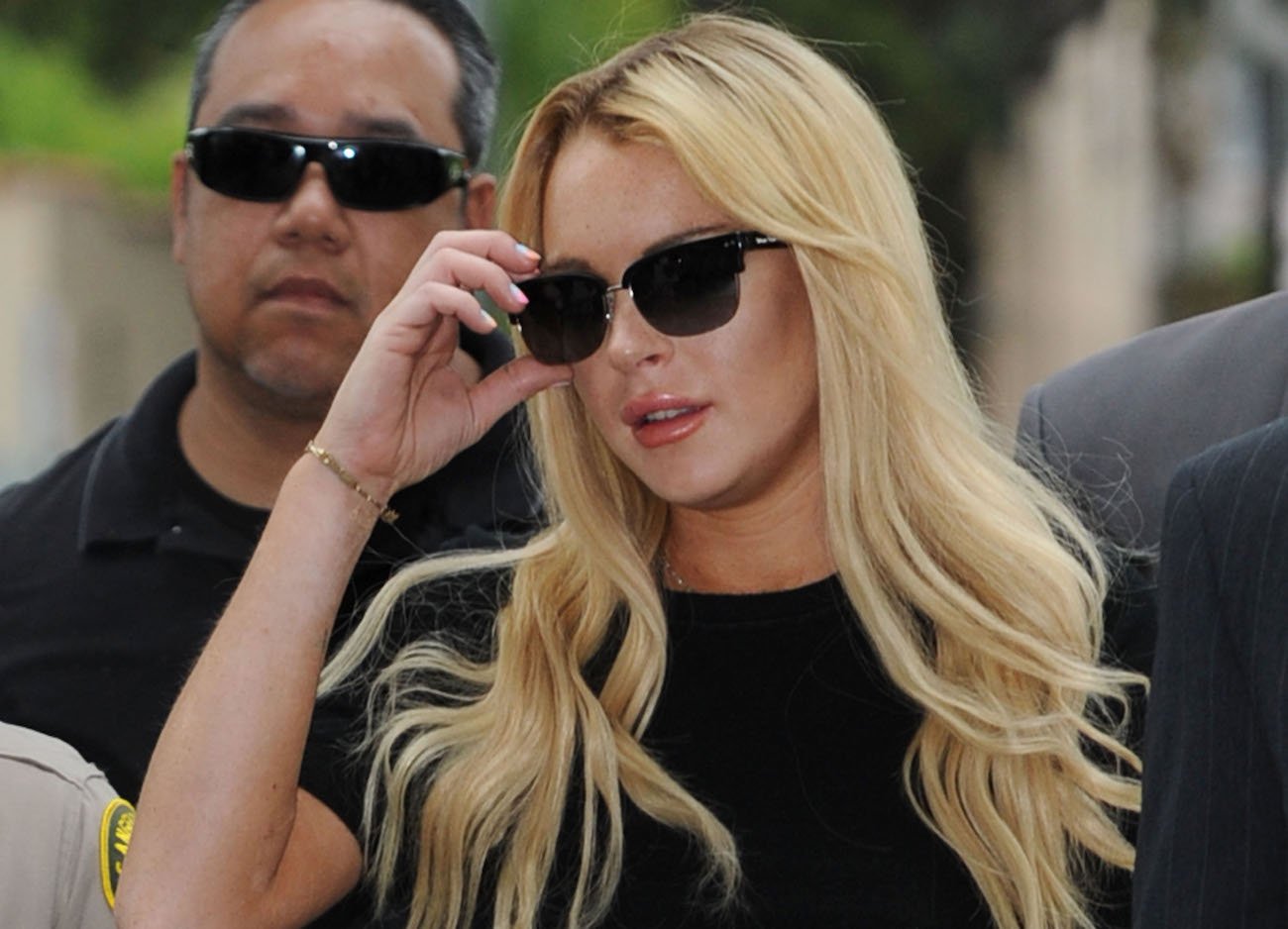 Lindsay Lohan with blond hair and wearing a dark sunglasses