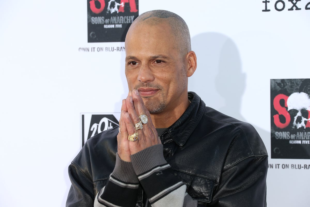David Labrava plays Happy in Mayans MC. Labrava wears a leather jacket and rings on his fingers. 