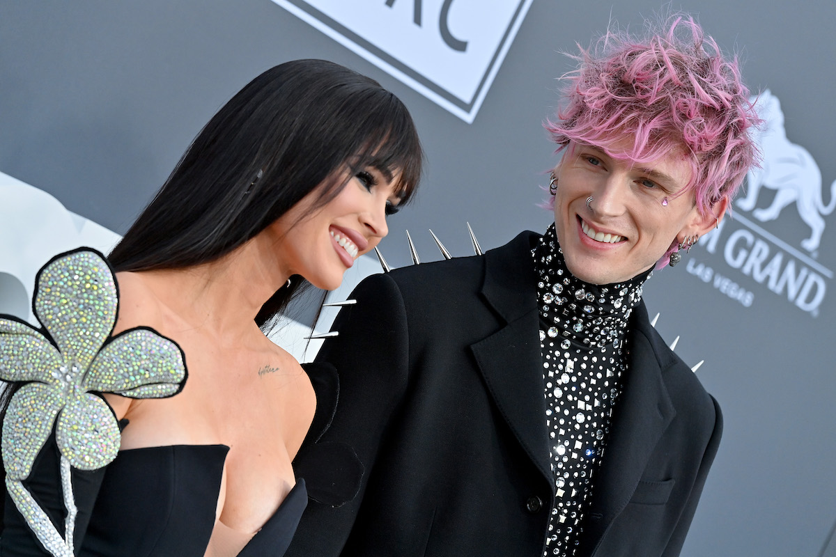 Megan Fox and Machine Gun Kelly smile together at an event.