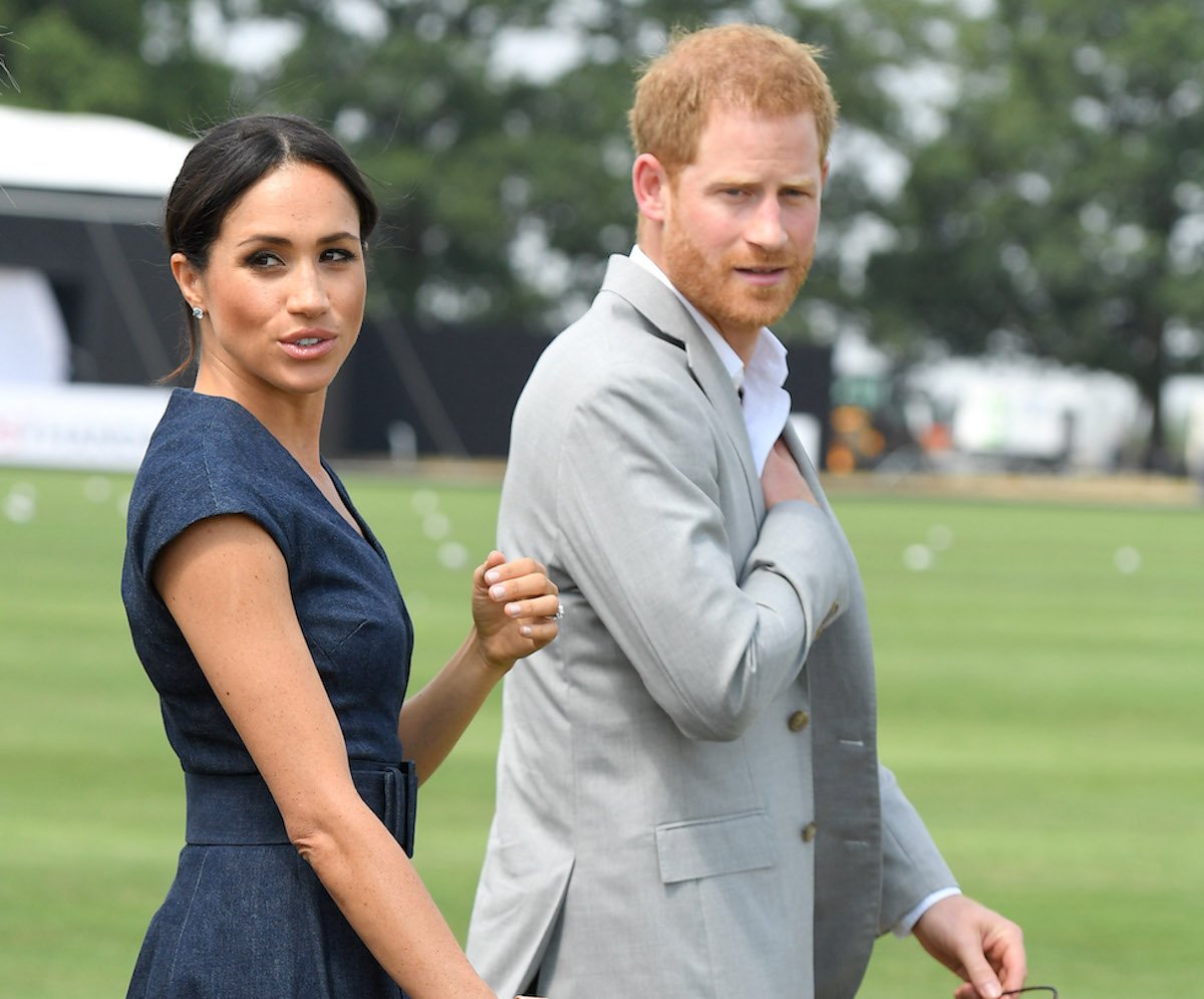 Meghan Markle and Prince Harry, who have appeared at polo matches together, walk next to each other at a 2018 polo match