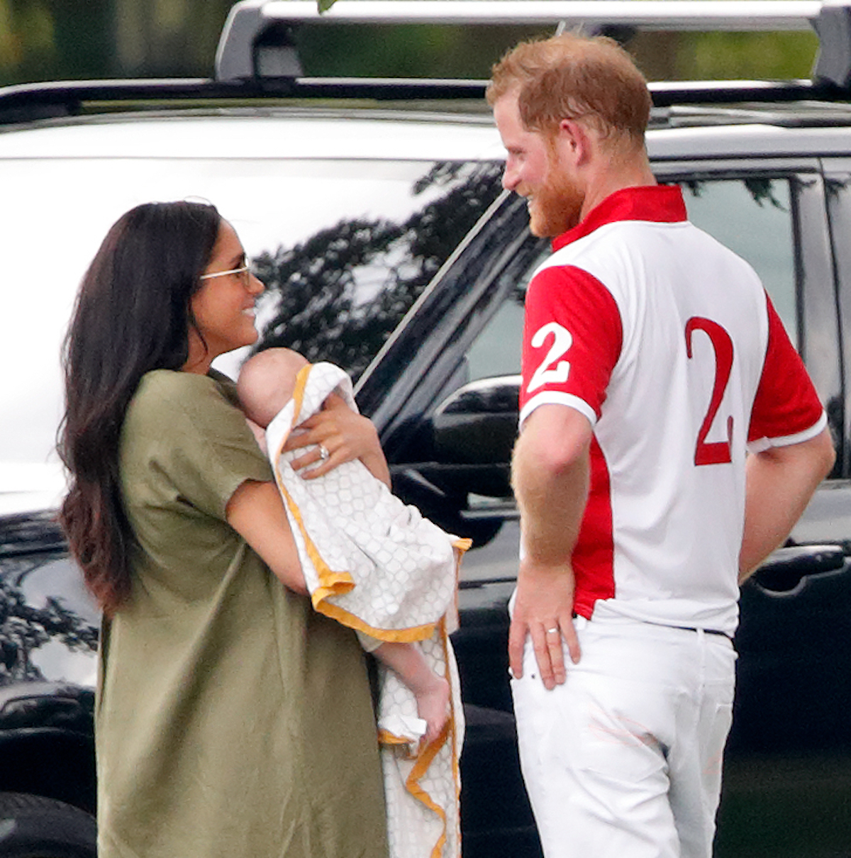 Meghan Markle, whose recent polo appearances an expert says could be 'trouble,' holds baby Archie as Prince Harry smiles