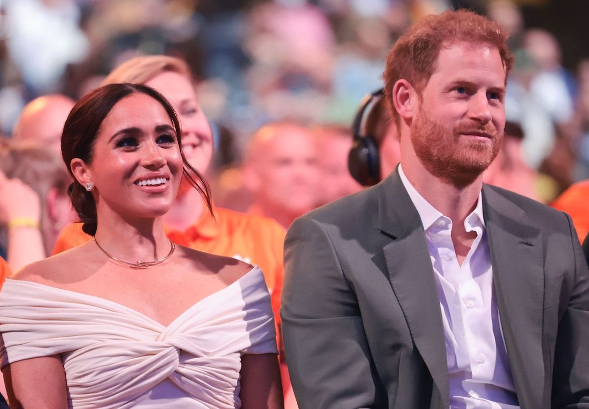 Meghan Markle and Prince Harry, who will supposedly be faces in the crowd at Queen Elizabeth II's Service of Thanksgiving, smile as they look on