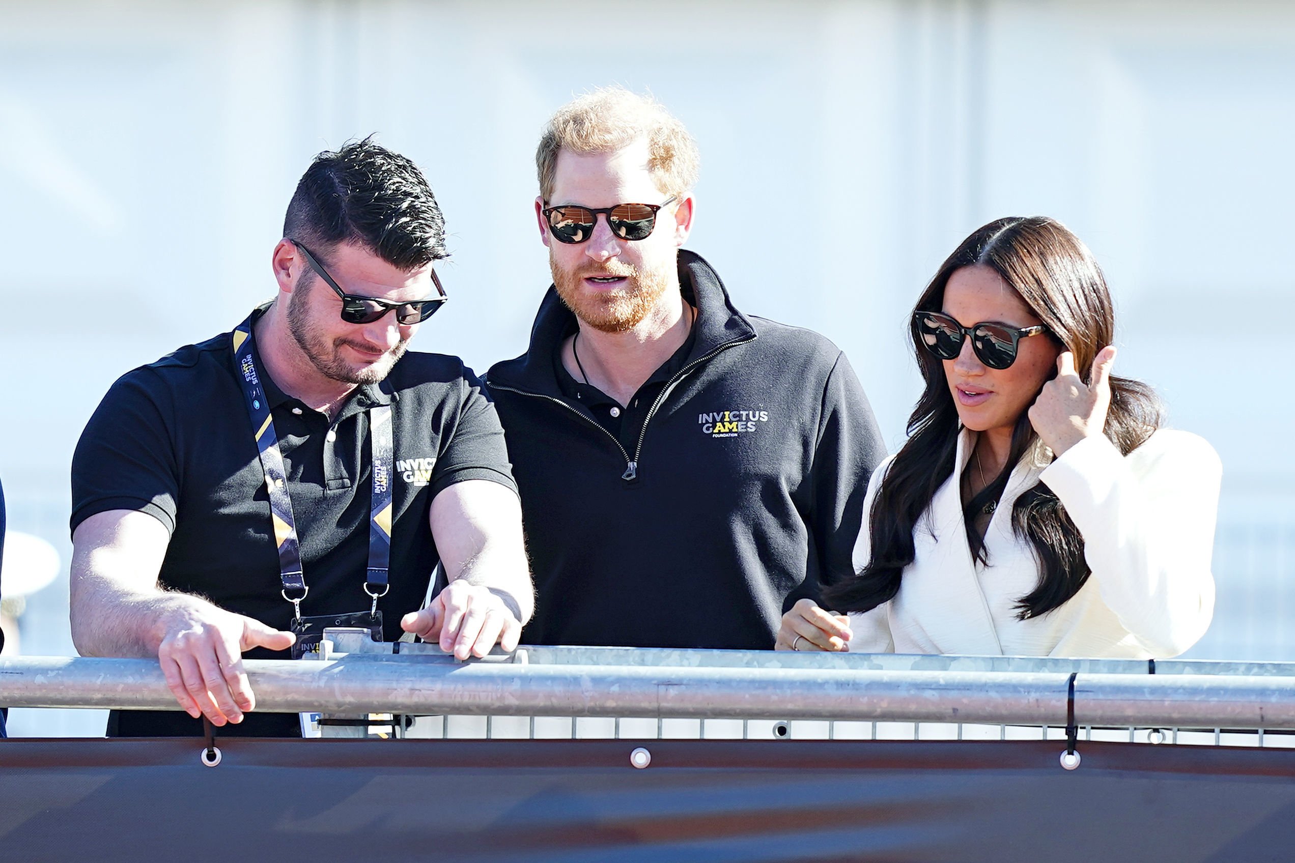 Meghan Markle and Prince Harry wearing sunglasses and standing next to Invictus Games trustee and Paralympian Dave Henson