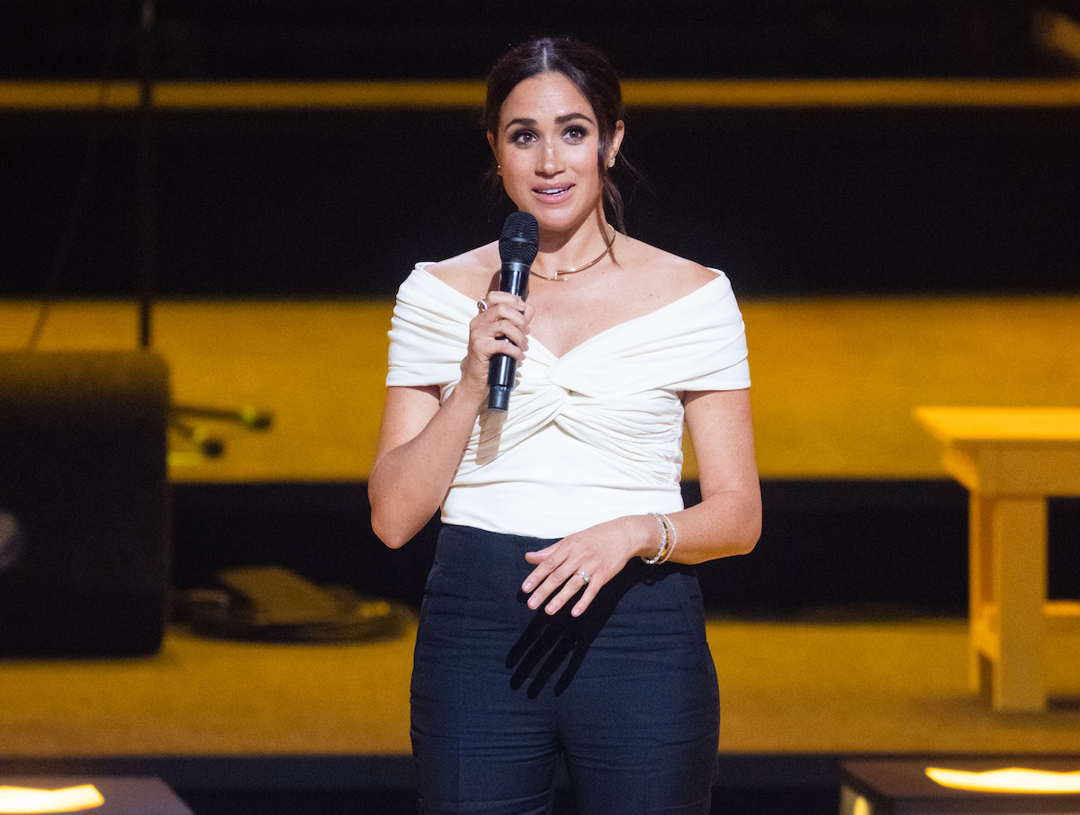 Meghan Markle, who according to a royal biographer would visit her father Thomas Markle if she were really 'compassionate,' speaks into a microphone