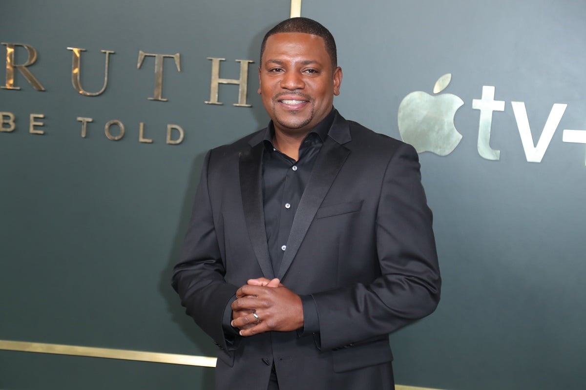 Mekhi Phifer smiling while wearing an all black suit.