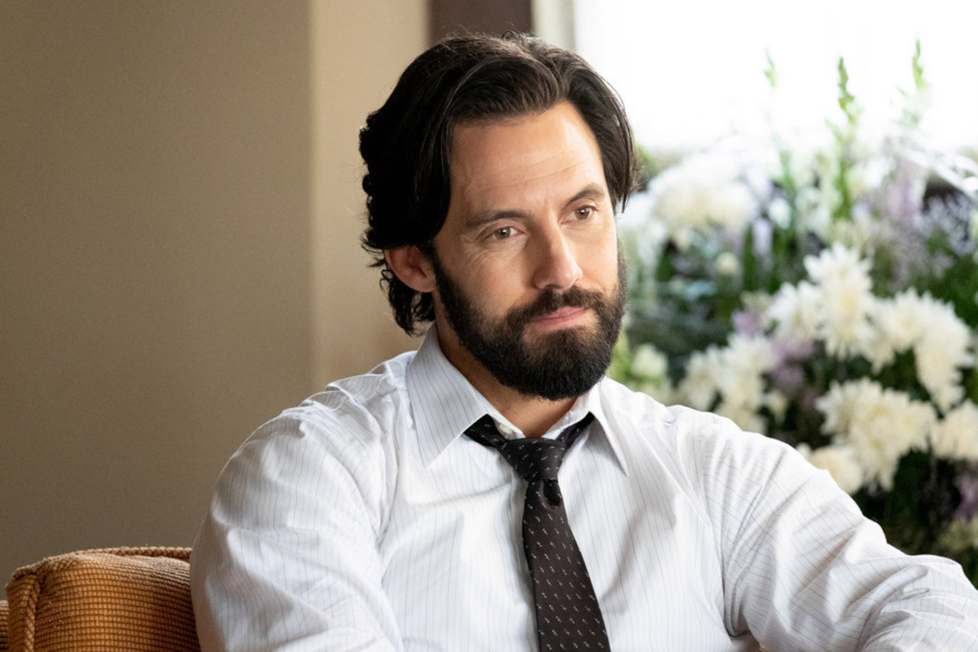 Milo Ventimiglia as Jack Pearson in 'This Is Us' Season 6. He's wearing a white shirt and black tie, and he's smiling.