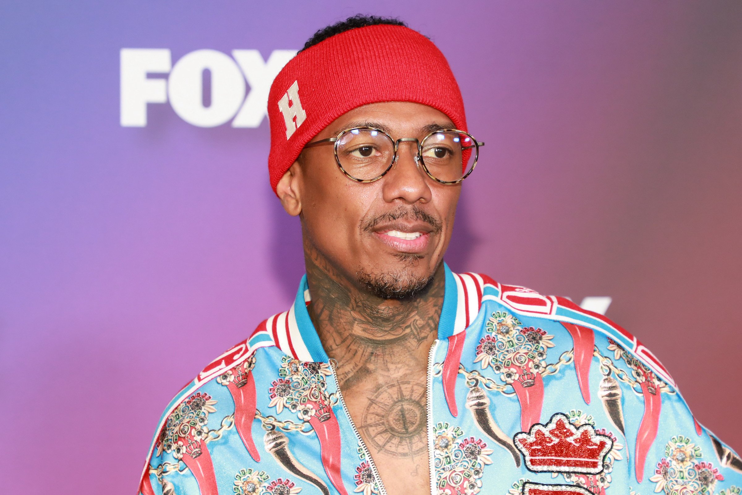Vasectomy candidate Nick Cannon wearing a red headband and blue shirt