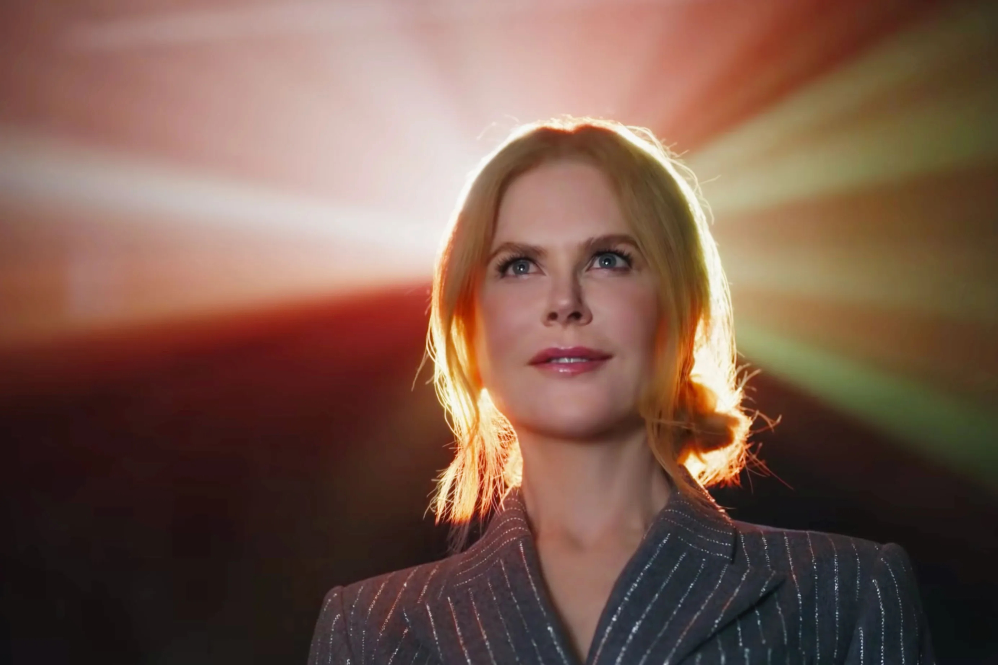 Nicole Kidman in AMC ad looking forward with a smile on her face with the light from the projector behind her
