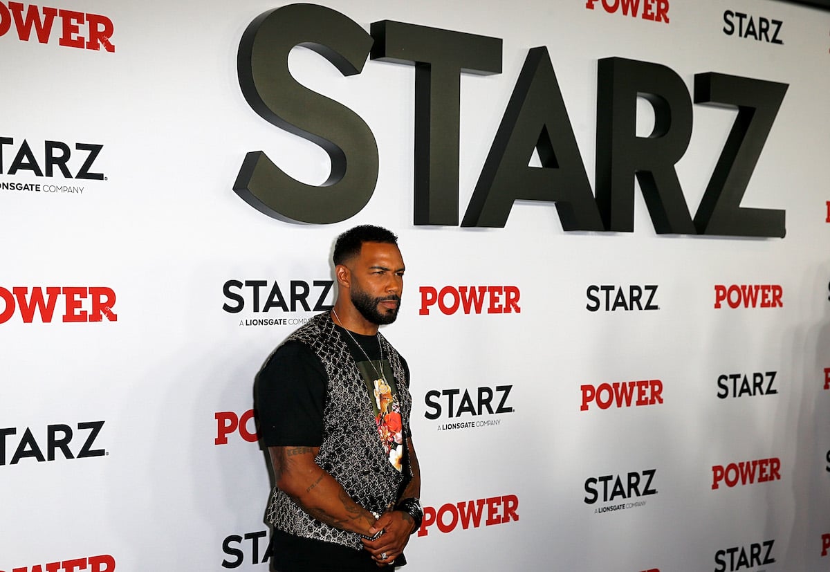 Omari Hardwick of 'Power' poses for a photo on the red carpet at an event for the show, wearing a black graphic T-shirt with a sparkly vest. Fans have wondered about Omari Hardwick's 'Power' salary due to him being a lead on the show.
