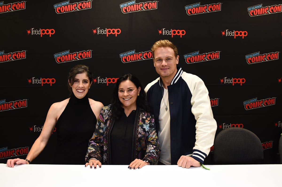 Outlander ep Maril Davis, author Diana Gabaldon, and star Sam Heughan pose for a photo after the Outlander panel during Day 3 of New York Comic Con 2021