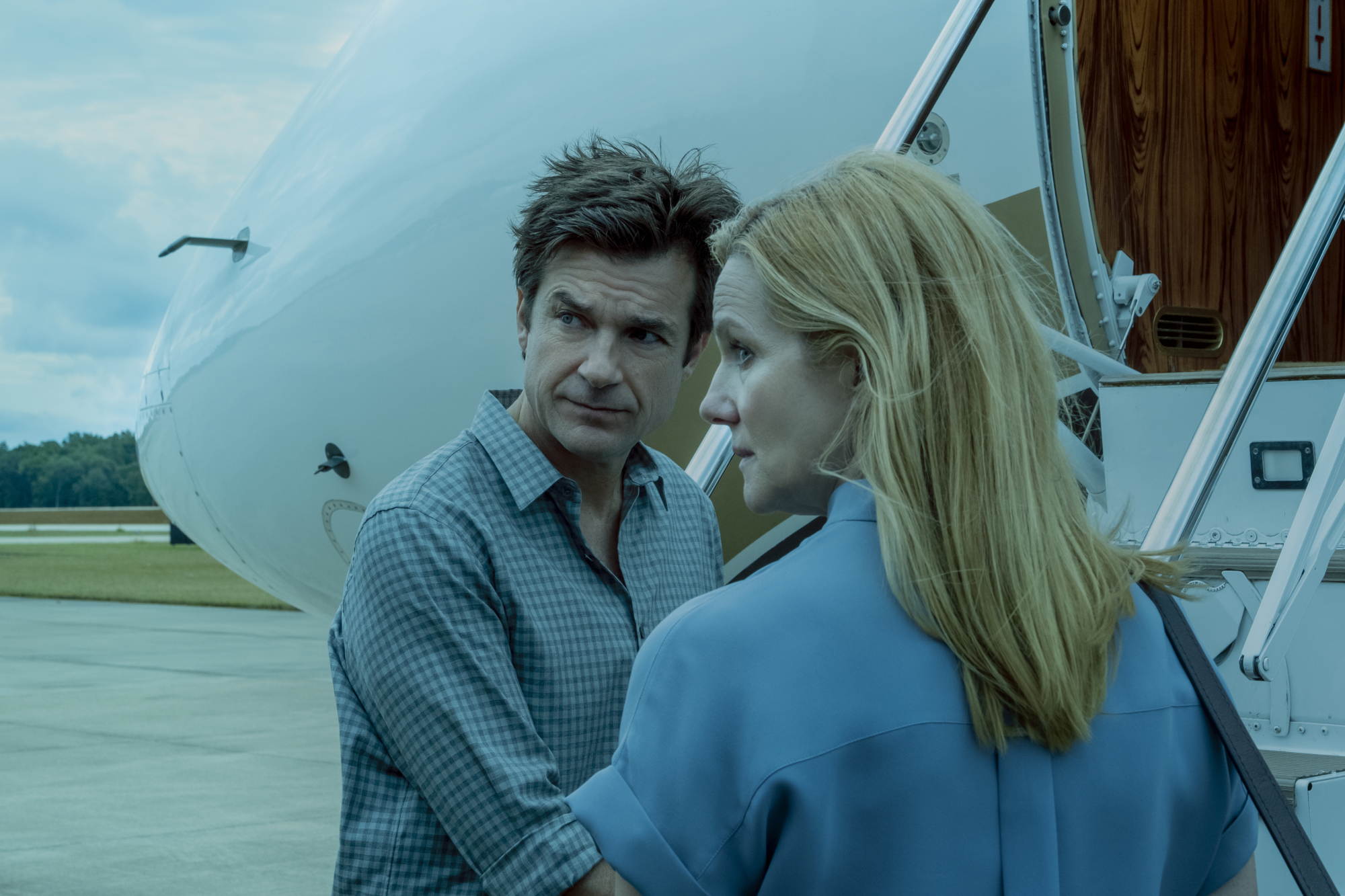 Jason Bateman and Laura Linney as Marty and Wendy Byrde in 'Ozark' Season 3. They're boarding a plan and looking back at something.