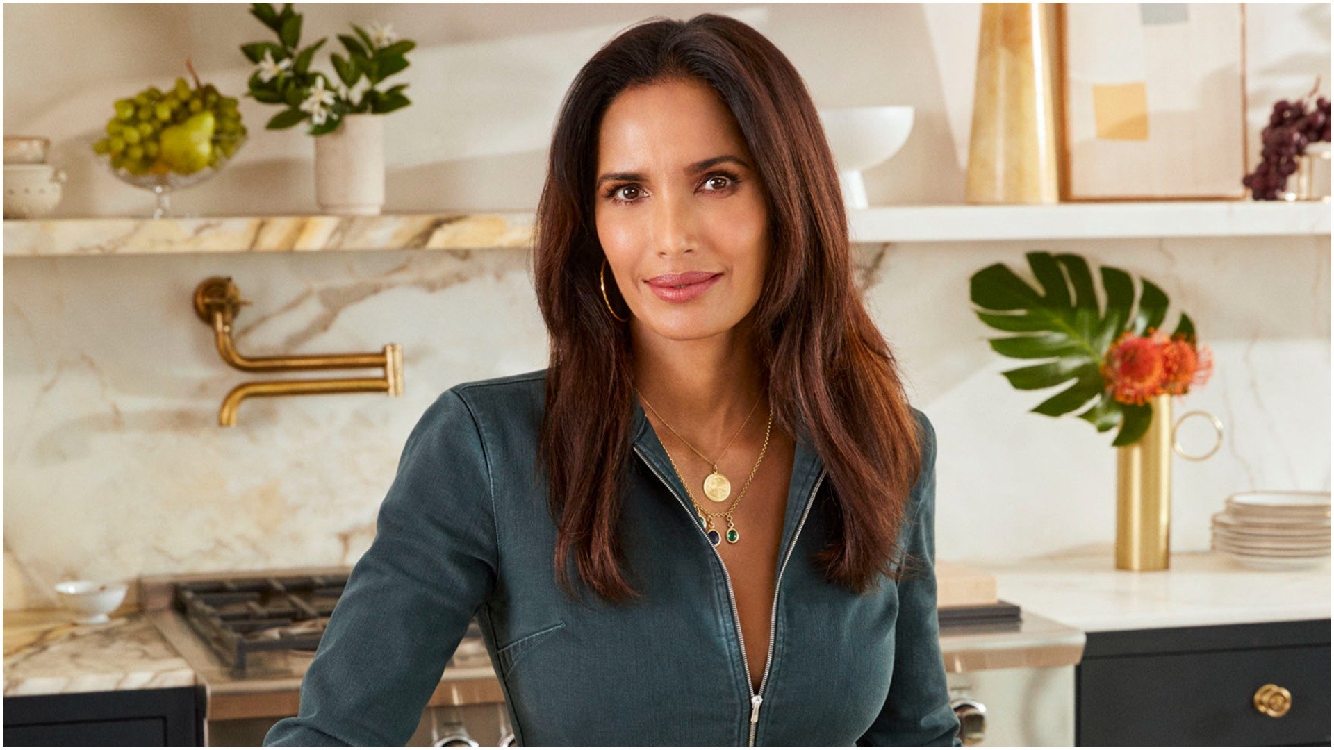 Padma Lakshmi from 'Top Chef' smiles while in her kitchen 