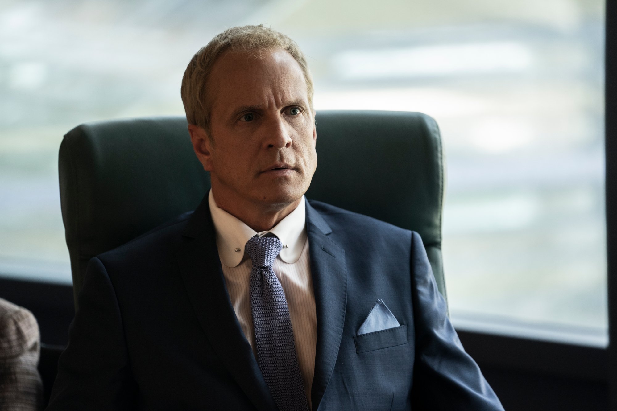 Patrick Fabian as Howard Hamlin in 'Better Call Saul' Season 6 Episode 7. He's wearing a dark blue suit and sitting at a desk.