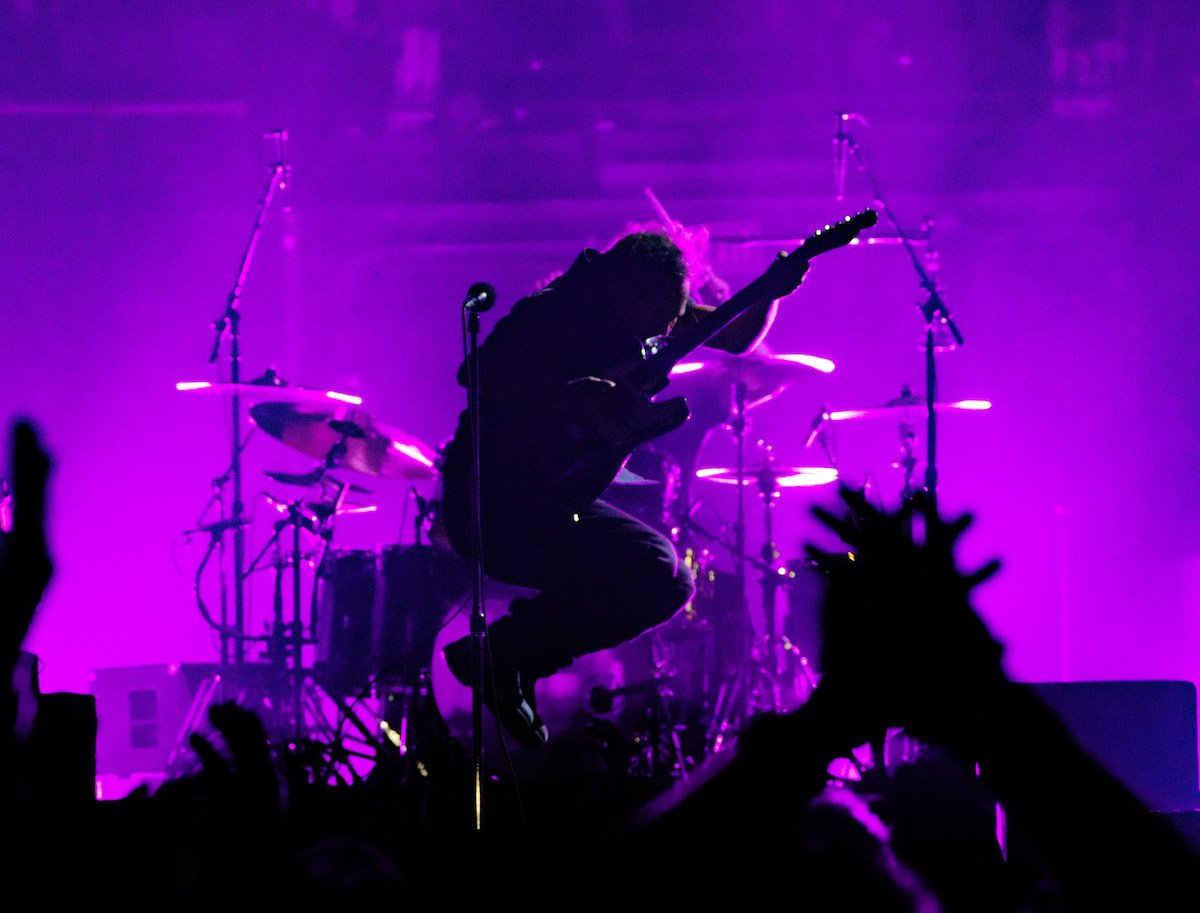 Eddie Vedder of Pearl Jam jumping while performing