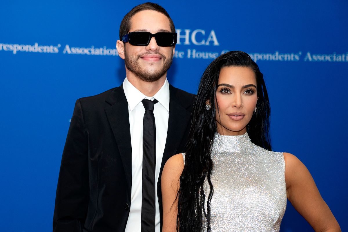 Pete Davidson and Kim Kardashian smile and pose together at an event.