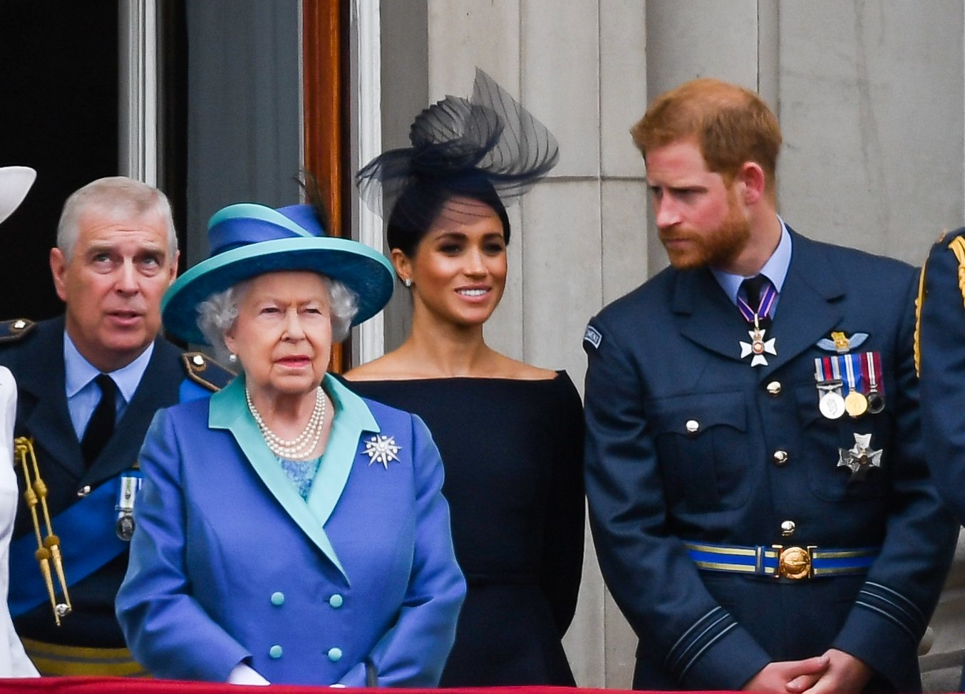 Queen Elizabeth II with Prince Andrew, Meghan Markle, and Prince Harry, who could all derail her Platinum Jubilee, standing on the royal balcony