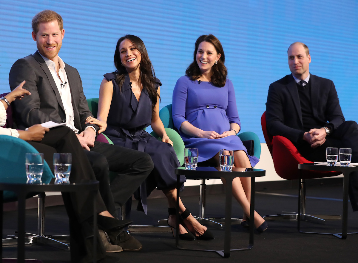 Prince Harry, Meghan Markle, Kate Middleton, and Prince William smile as they sit on stage at the Royal Foundation Forum