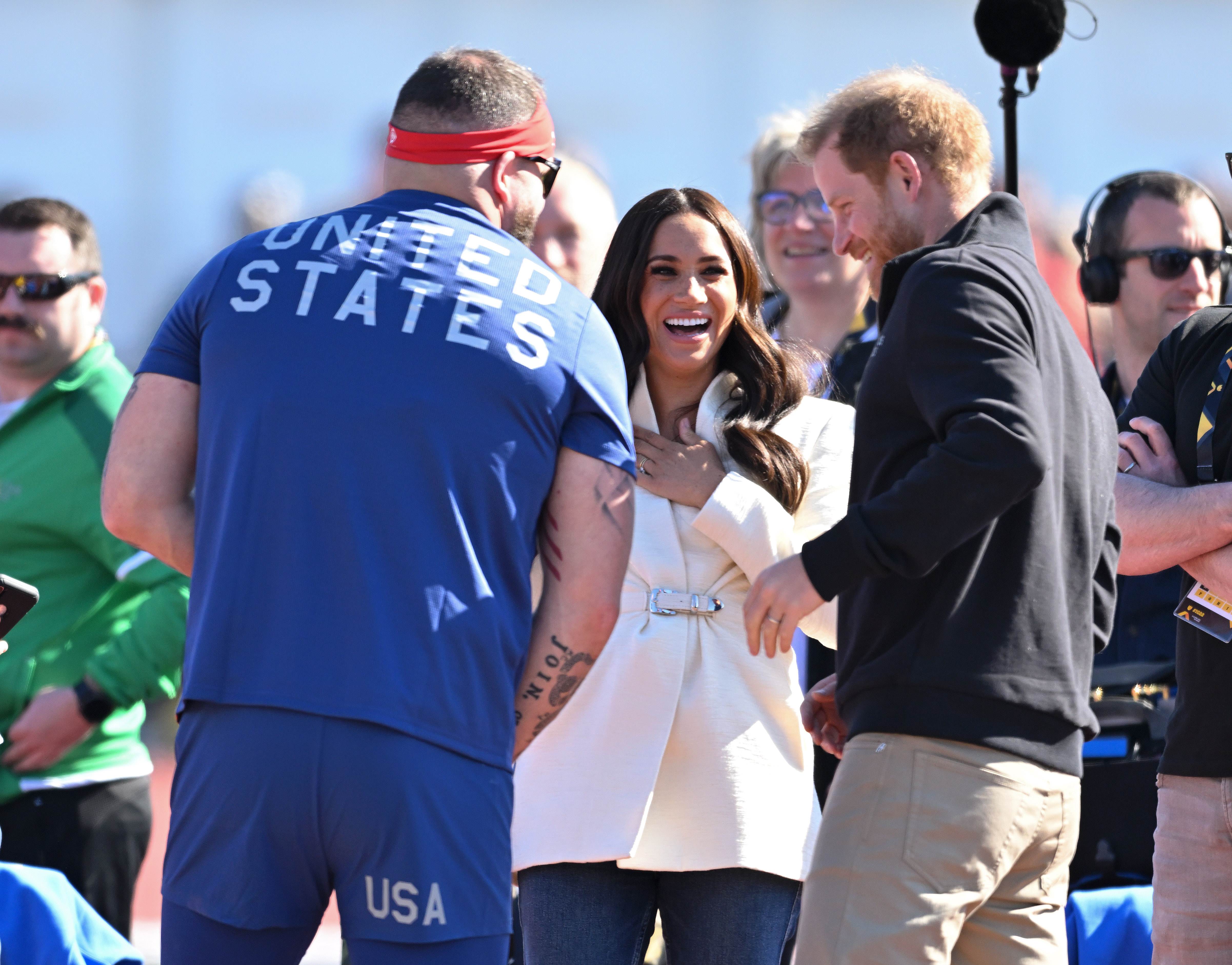 Prince Harry and Meghan Markle laughing with U.S. athlete at Invictus Games 