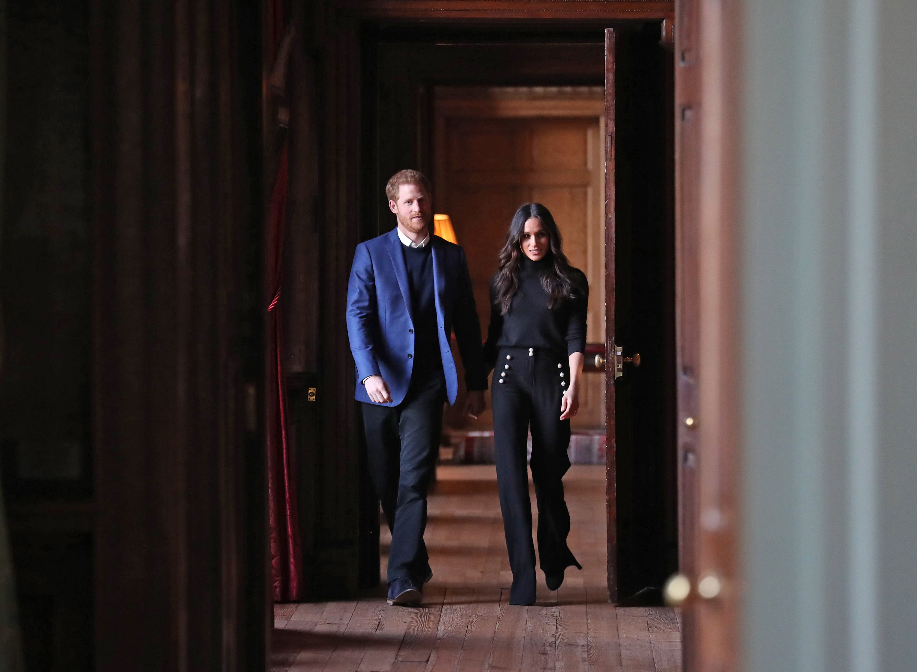 A body language expert analyzed a photo of Meghan Markle and Prince Harry who are seen here walking together through the corridors of the Palace of Holyroodhouse
