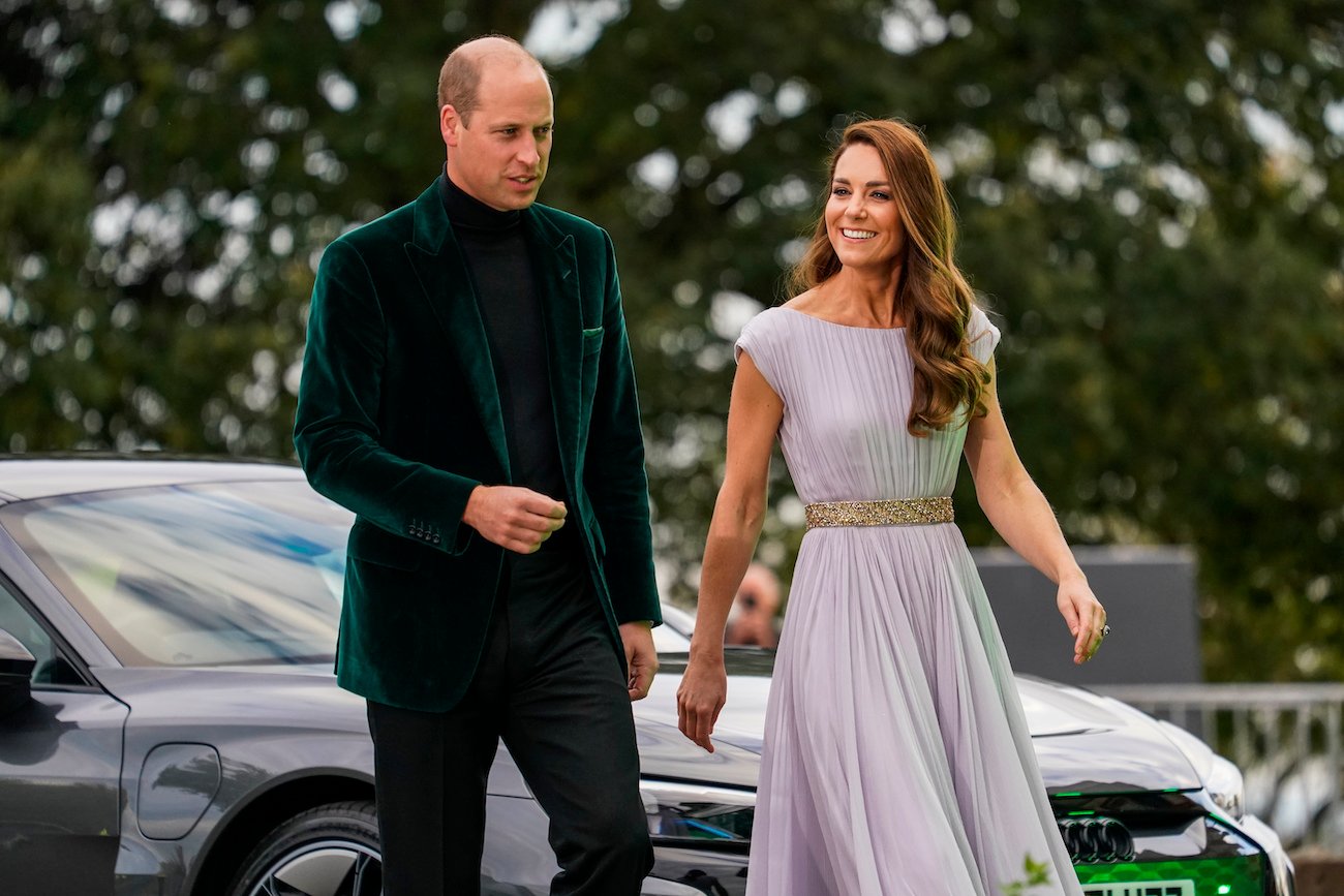 Prince William wearing a dark green suit and Kate Middleton wearing a light violet dress