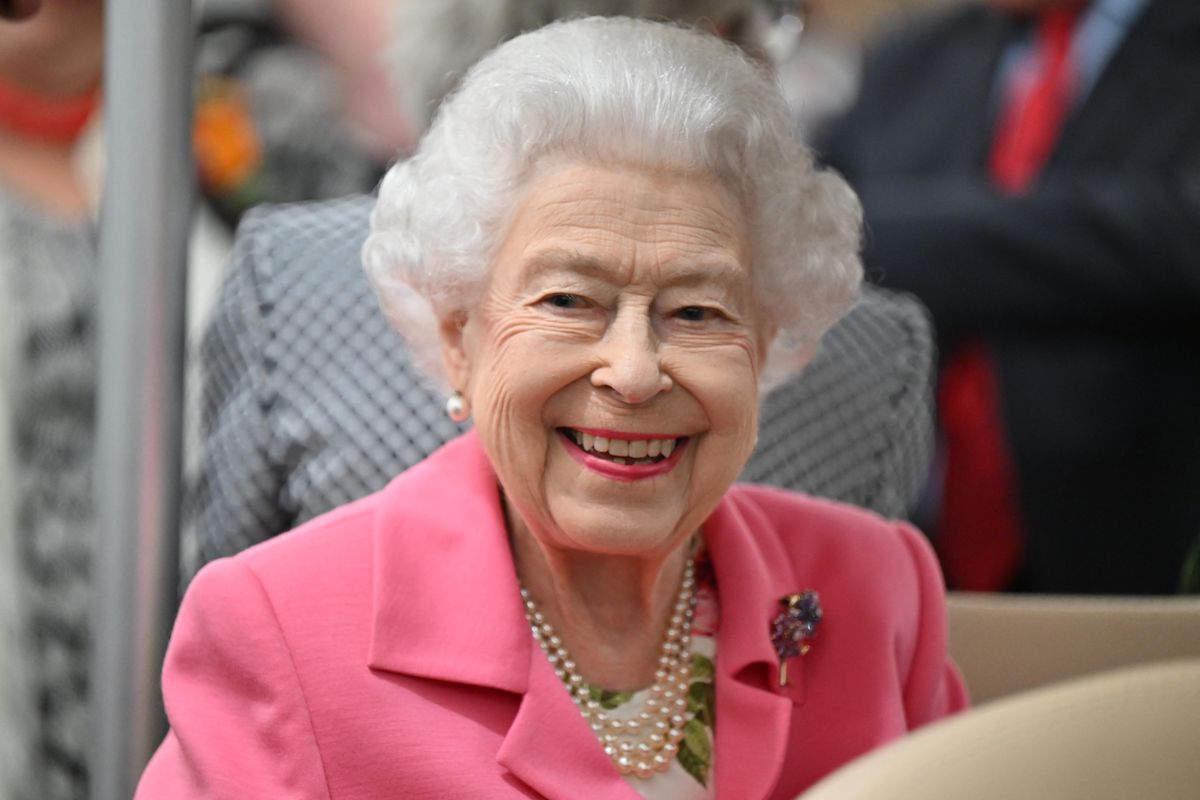 Queen Elizabeth II, who toured the Chelsea Flower Show in a golf cart, smiles wearing a pink blazer