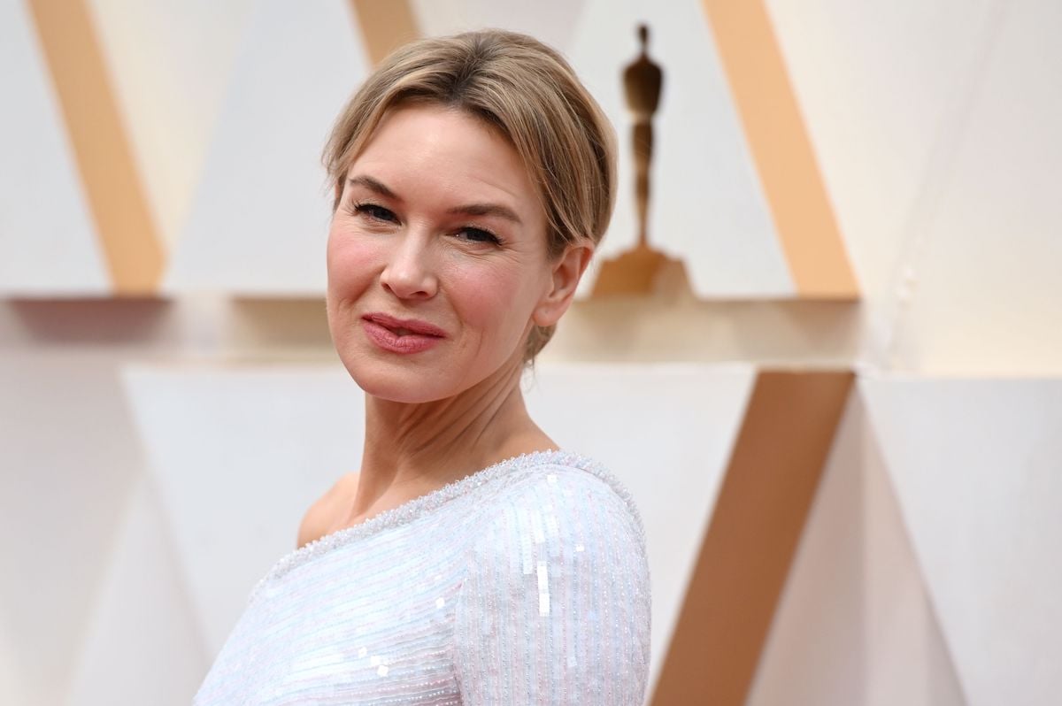 Renee Zellweger smiles and poses at an event.