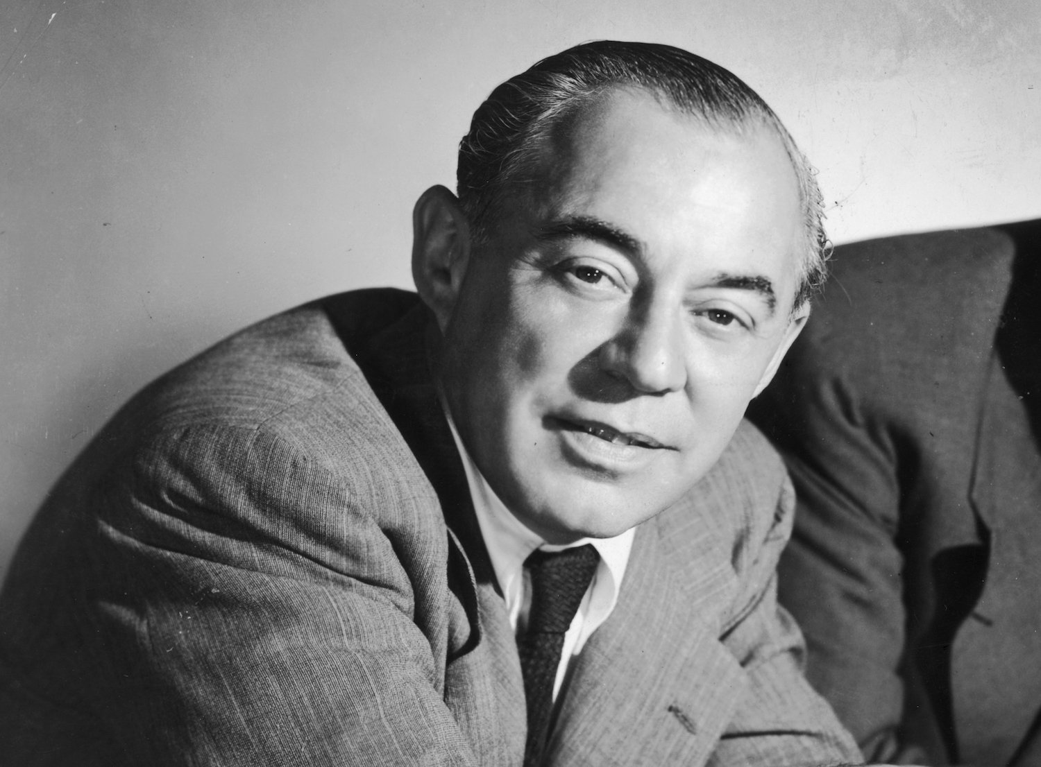 Studio portrait of American musical team, composer Richard Rodgers (L), (1902 - 1979) leaning over a piano.