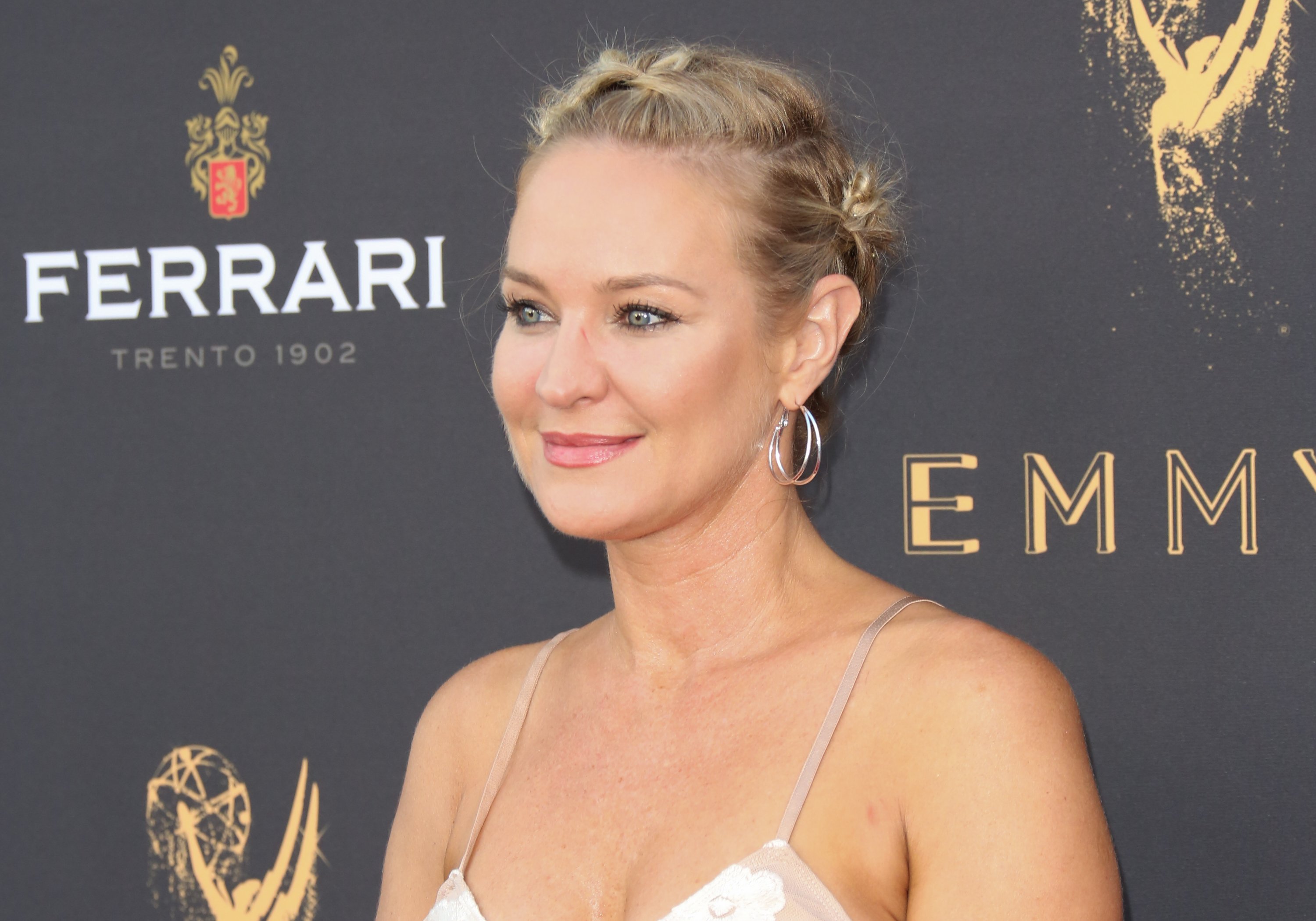 'The Young and the Restless' actor Sharon Case wearing a white dress and sporting an updo.