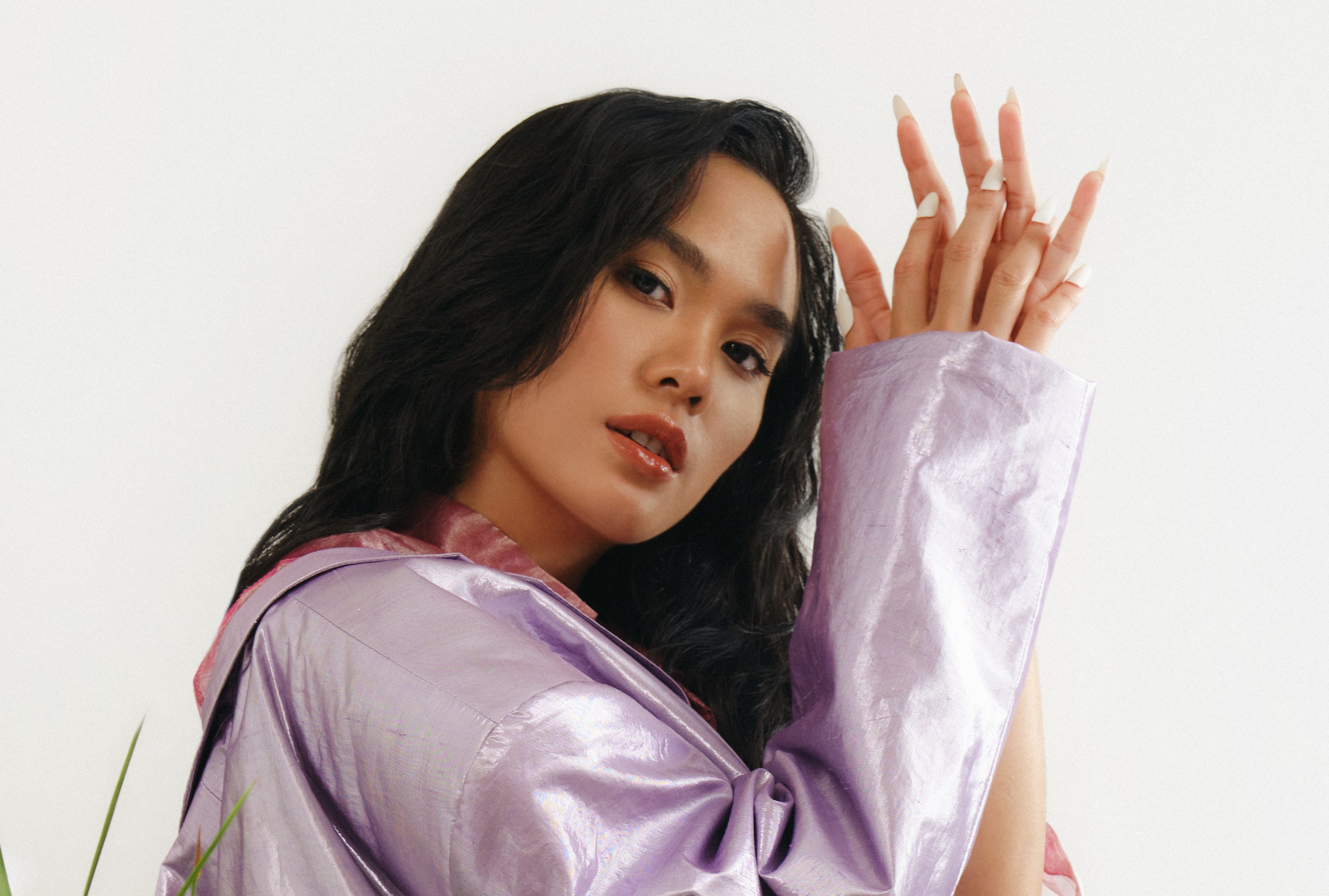 Sheryl Sheinafia looks into the camera while holding up her hands