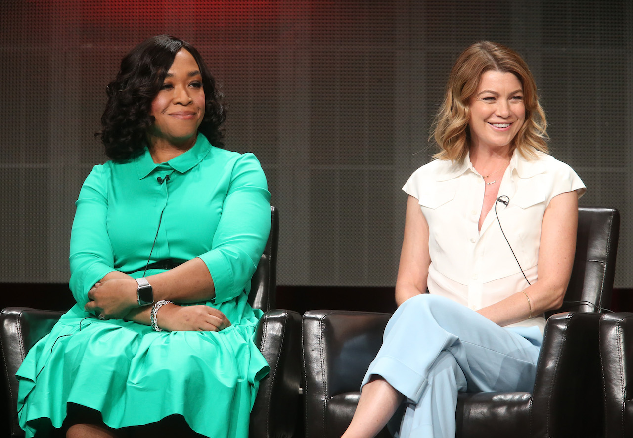 Shonda Rhimes wears a green dress and Ellen Pompeo wears a white shirt and jeans. They sit together on stage.