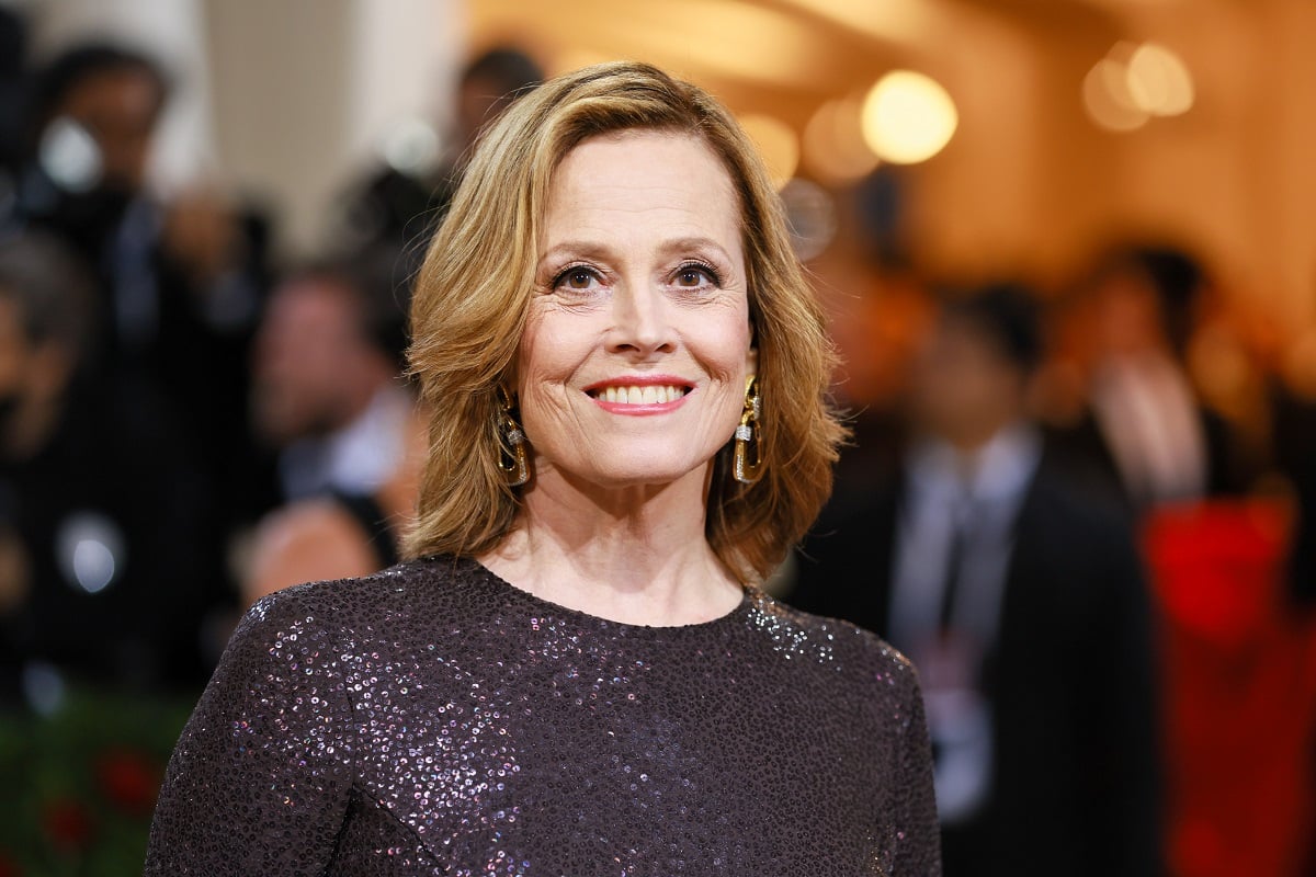 Sigourney Weaver smiling while wearing a black dress.