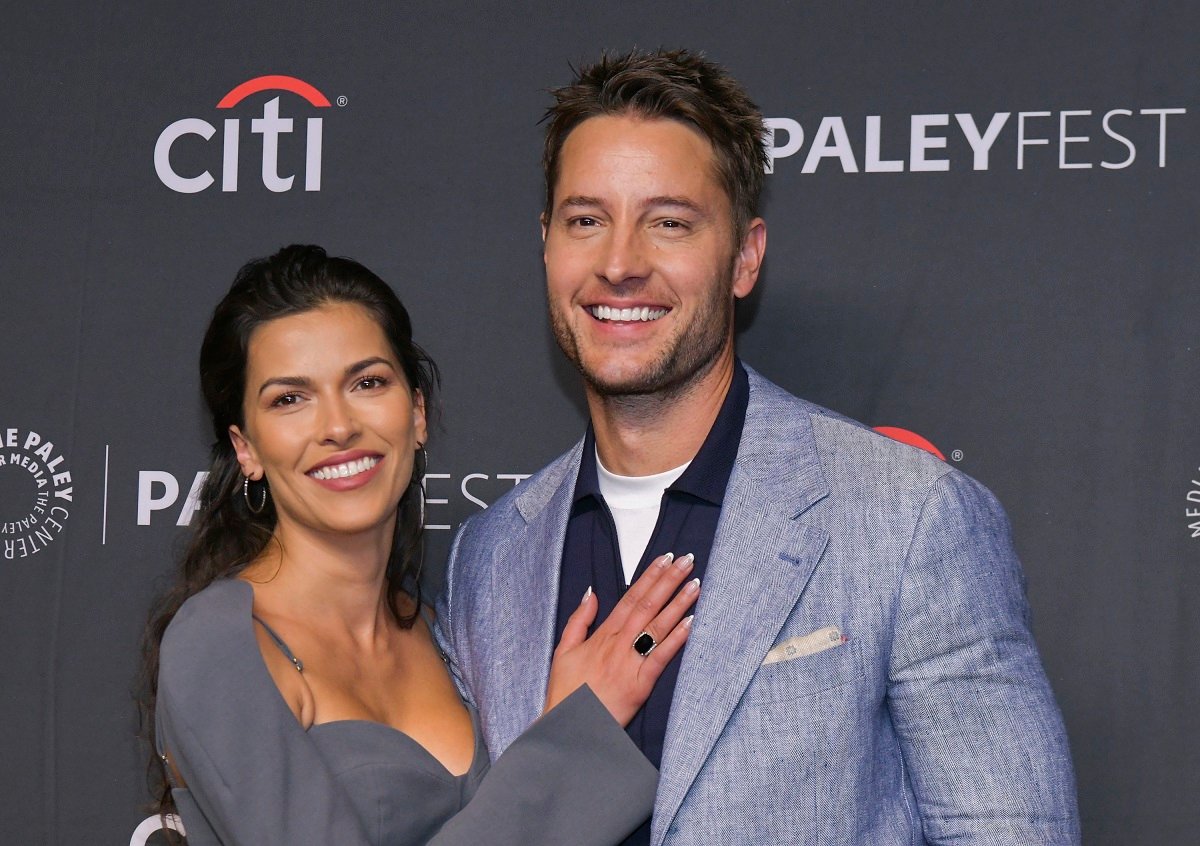 Sofia Pernas and Justin Hartley both dressed in grey, post together on the red carpet.
