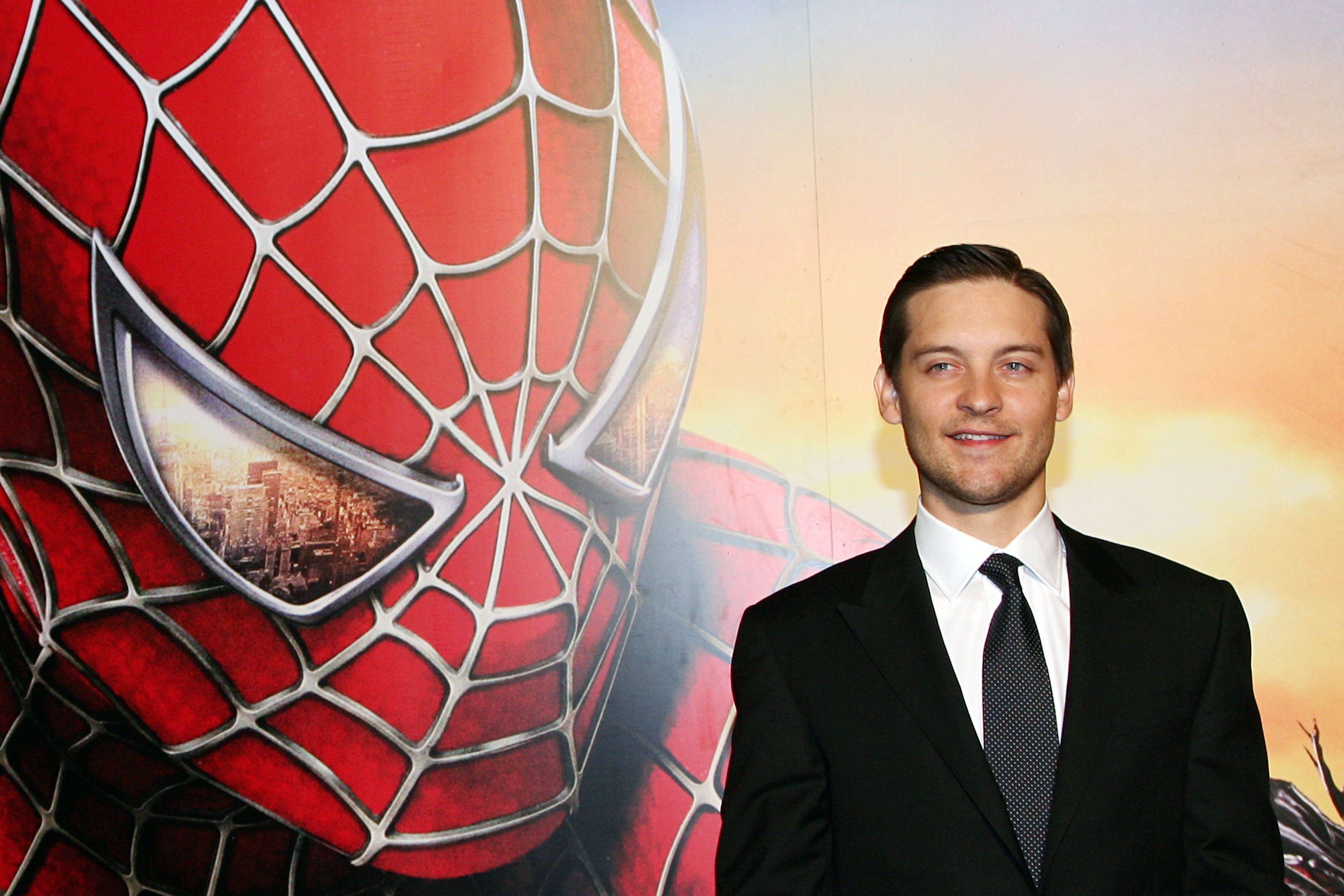 Tobey Maguire, who starred in the 'Spider-Man' movie, wears a black suit over a white button-up shirt and gray tie.