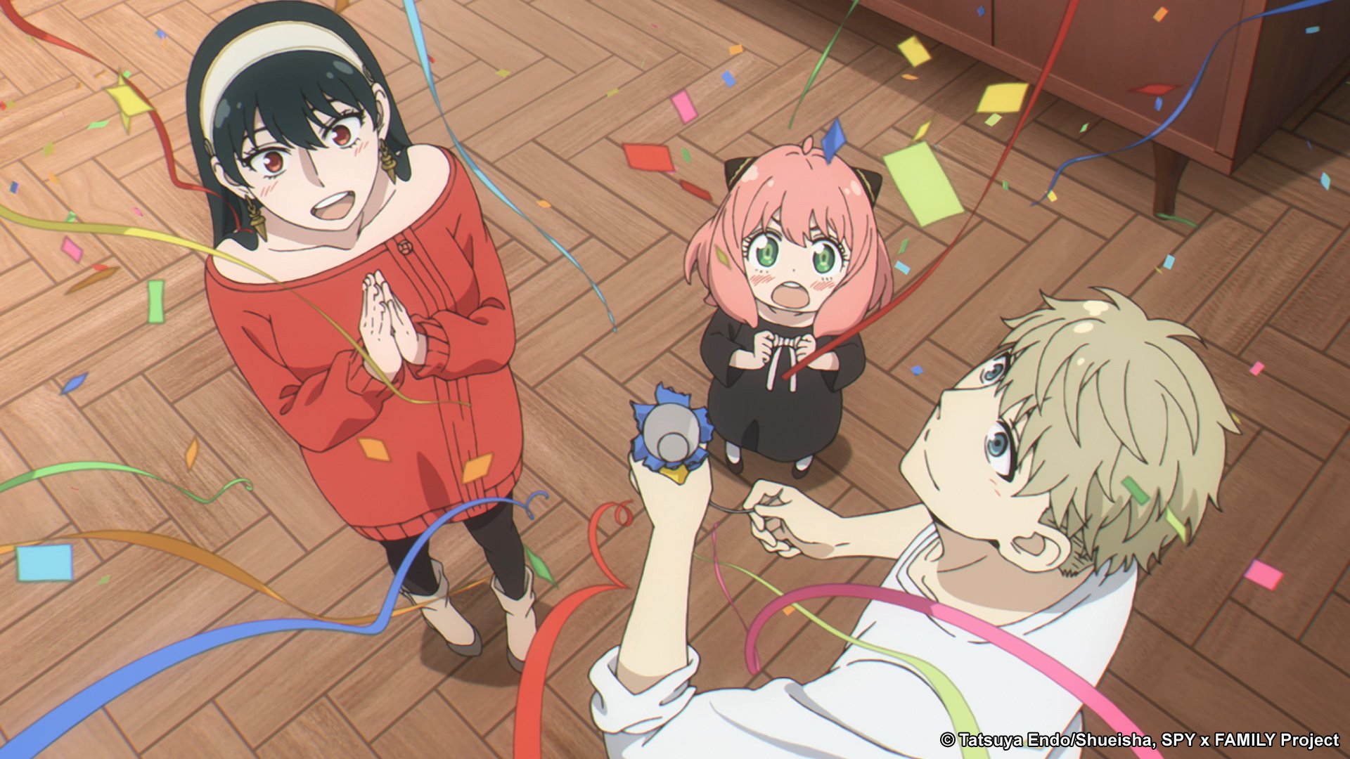 Yor, Anya, and Loid Forger celebrating in 'Spy x Family' Episode 5. They're releasing streamers and smiling.