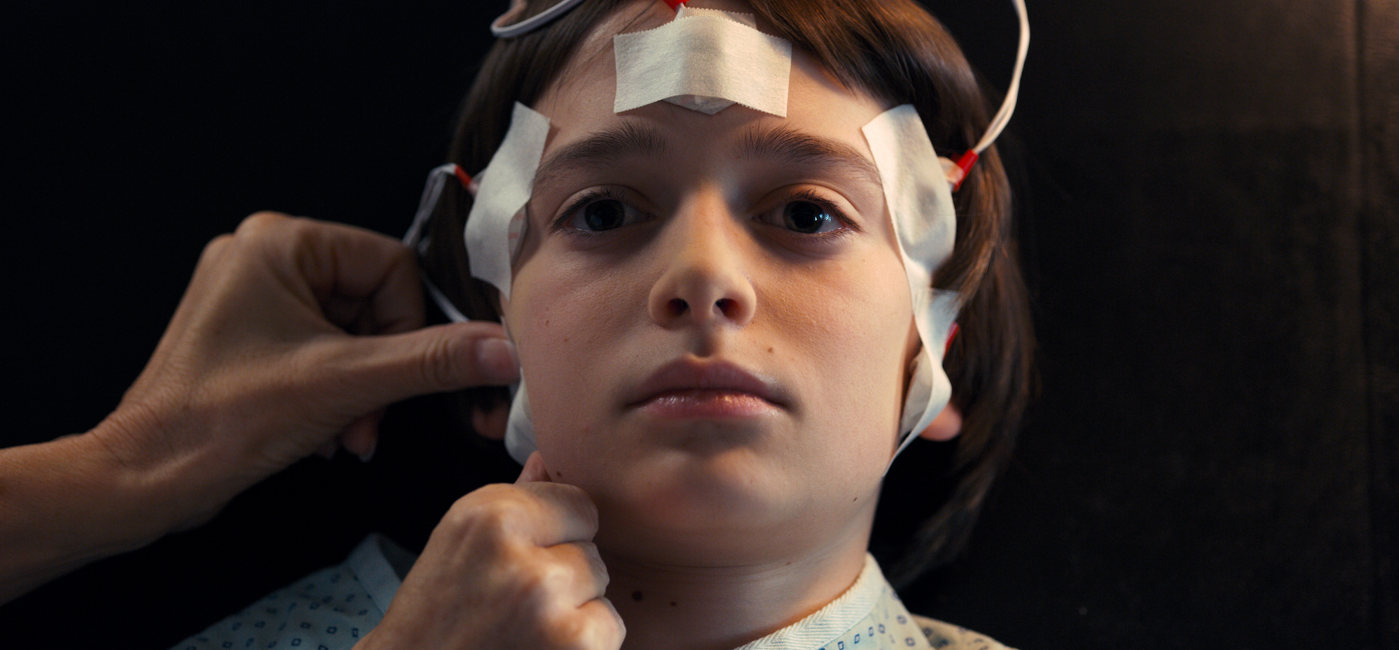 This 'Stranger Things' Season 2 recap features Noah Schnapp, as Will Byers, seen here with wires taped to his head in a production still from the series.