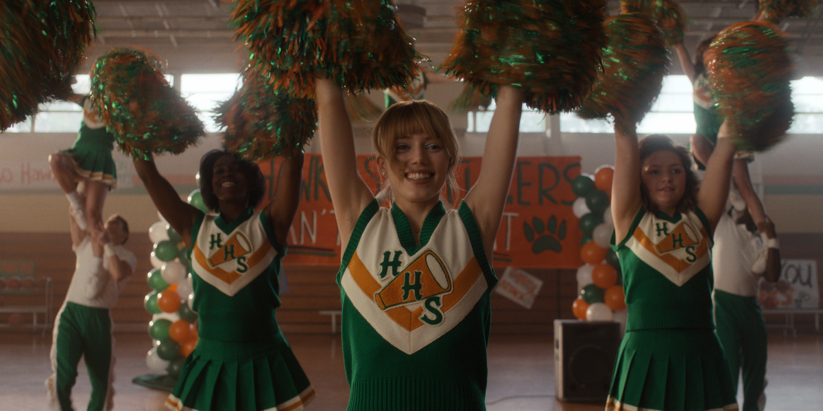 Grace Van Dien as Chrissy in 'Stranger Things' Season 4. Chrissy wears a cheerleading outfit and waves pom poms. 
