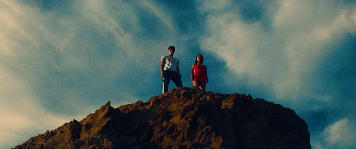 Raymond Baur as Noe and Maïra Villena as Cassandra standing on a cliff in 'Summer Scars'