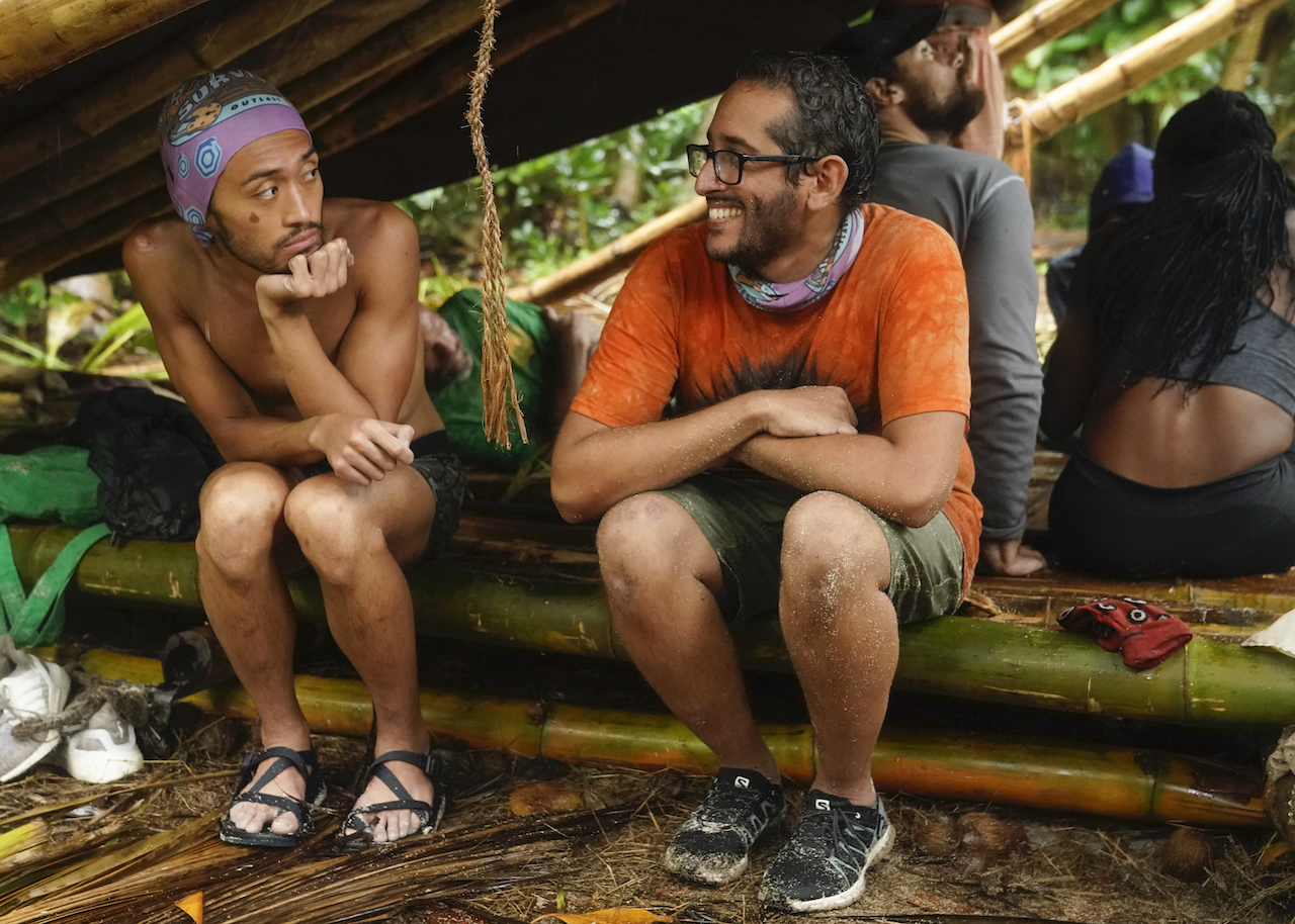 Hai Giang and Omar Zaheer sit together at camp on 'Survivor'.