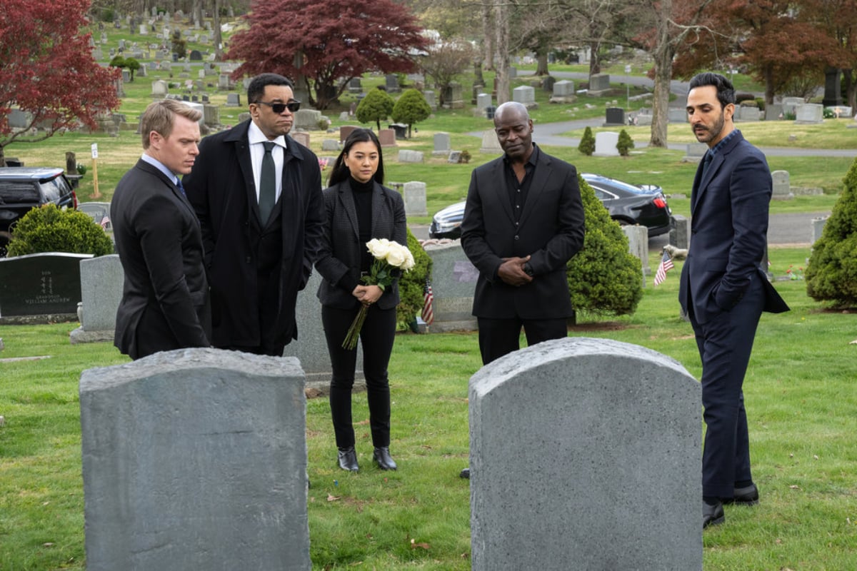 The task force, including Amir Arison as Aram, stand by Liz's grave in The Blacklist Season 9 finale. 