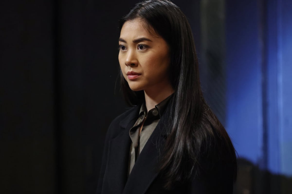 Laura Sohn as Alina Park in The Blacklist Season 9. Park wears a button-down shirt and a jacket. 