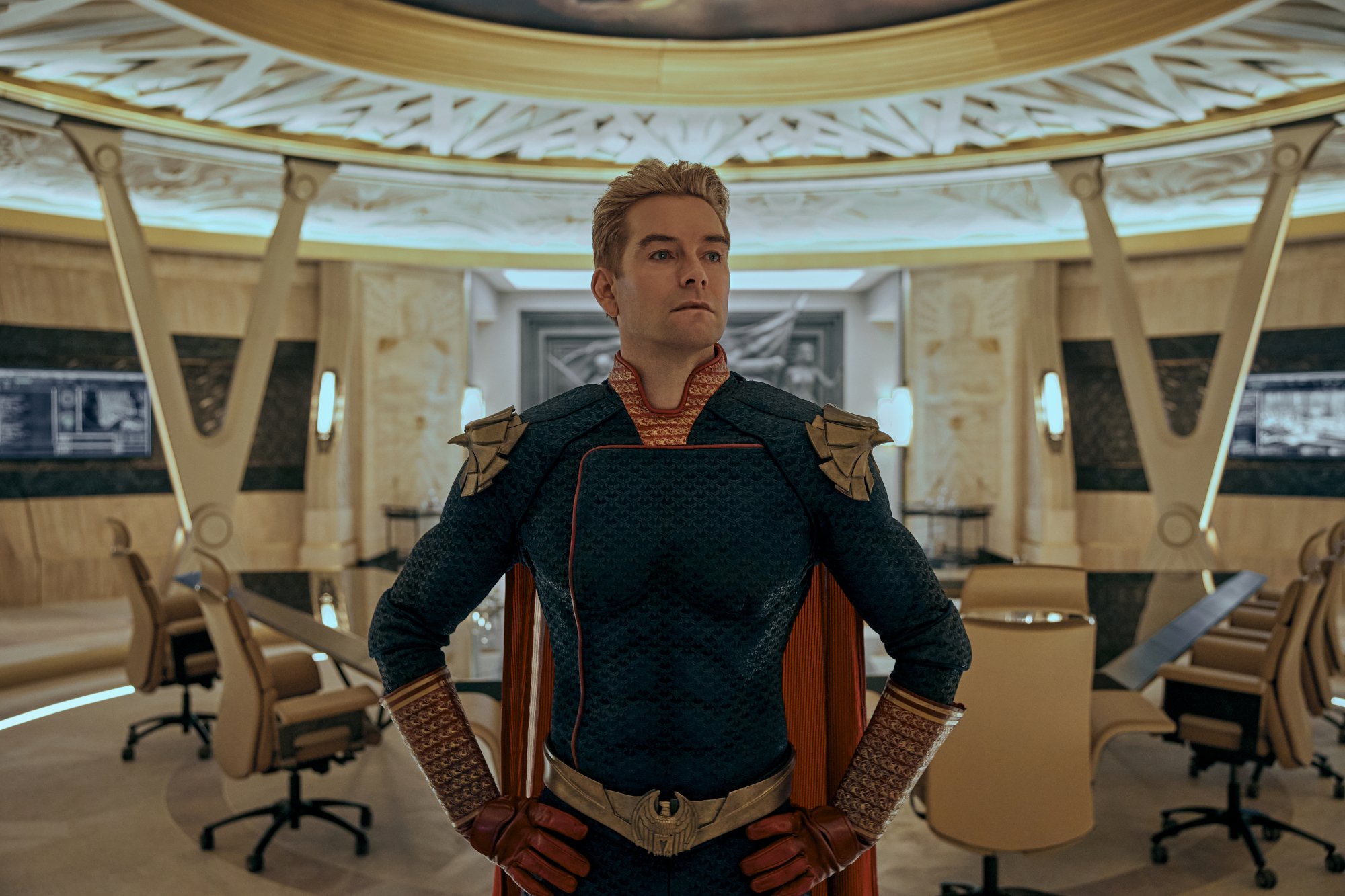 Antony Starr as Homelander in 'The Boys' Season 3, which has a release date of June 3. He's standing in a conference room, and his hands are on his hips.