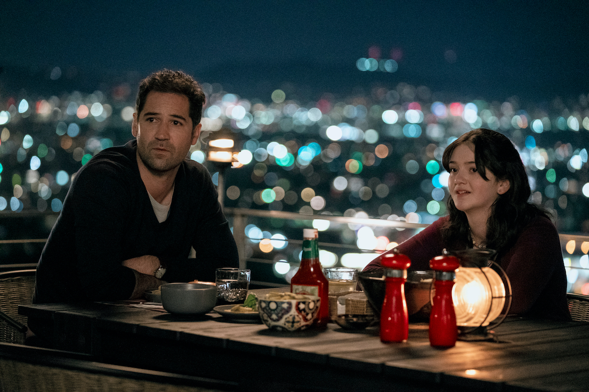 'The Lincoln Lawyer' cast members Manuel Garcia-Rulfo and Krista Warner sitting on a deck overlooking Los Angeles at night