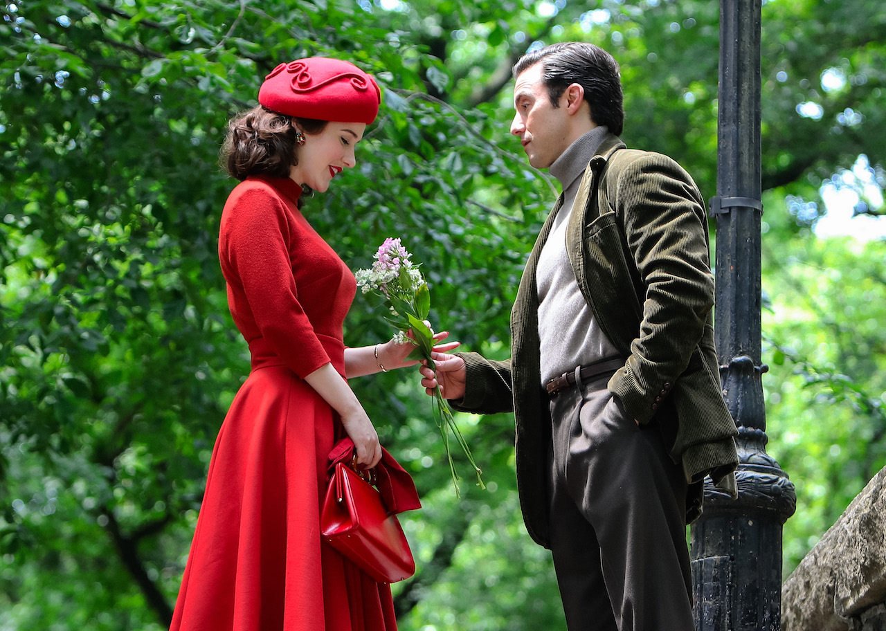 Milo Ventimiglia gives Rachel Brosnahan flowers in Central Park on the set of 'The Marvelous Mrs. Maisel'.