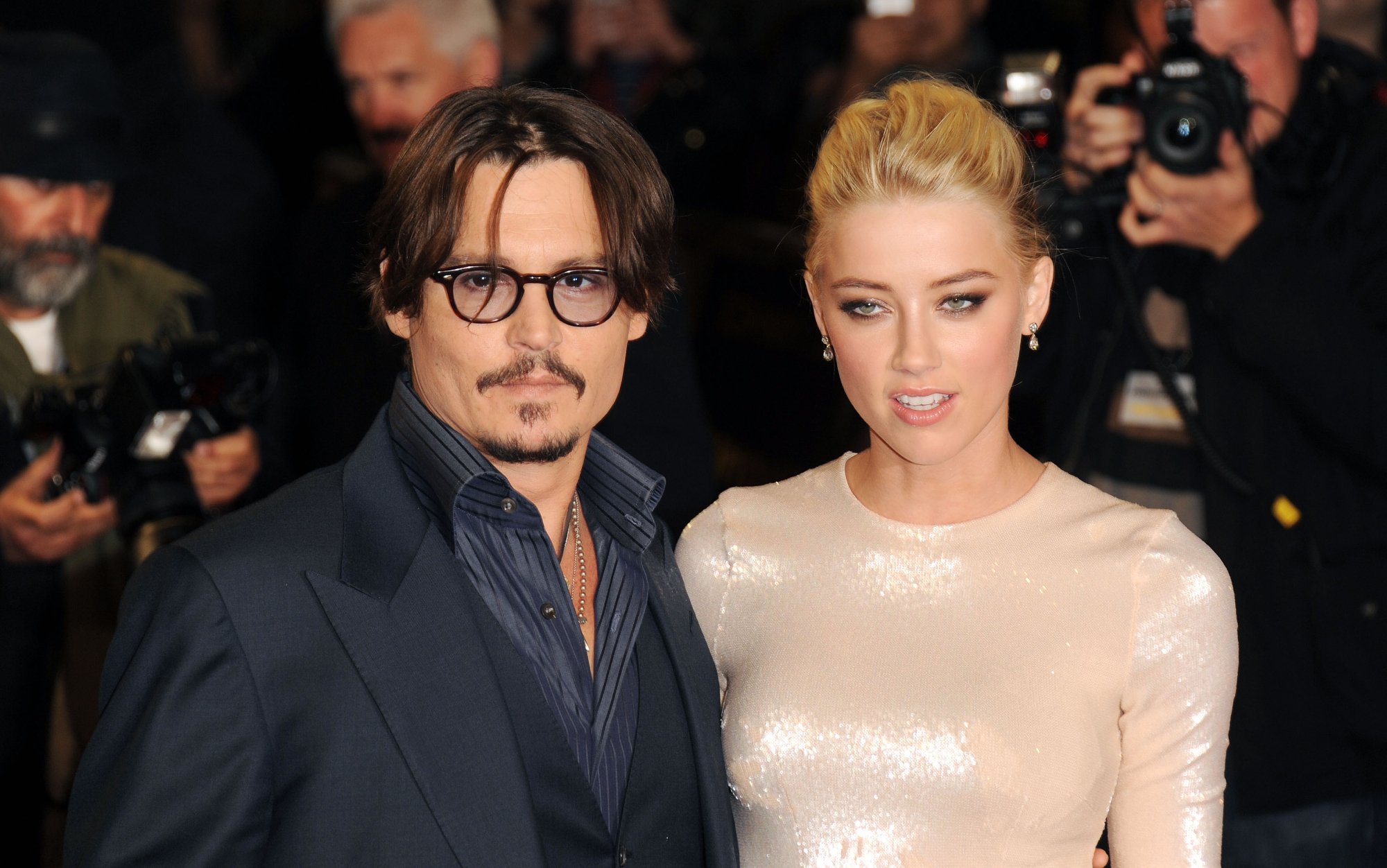 'The Rum Diary' stars Johnny Depp and Amber Heard getting interview footage on the red carpet posing together for photographs with photographers in the background