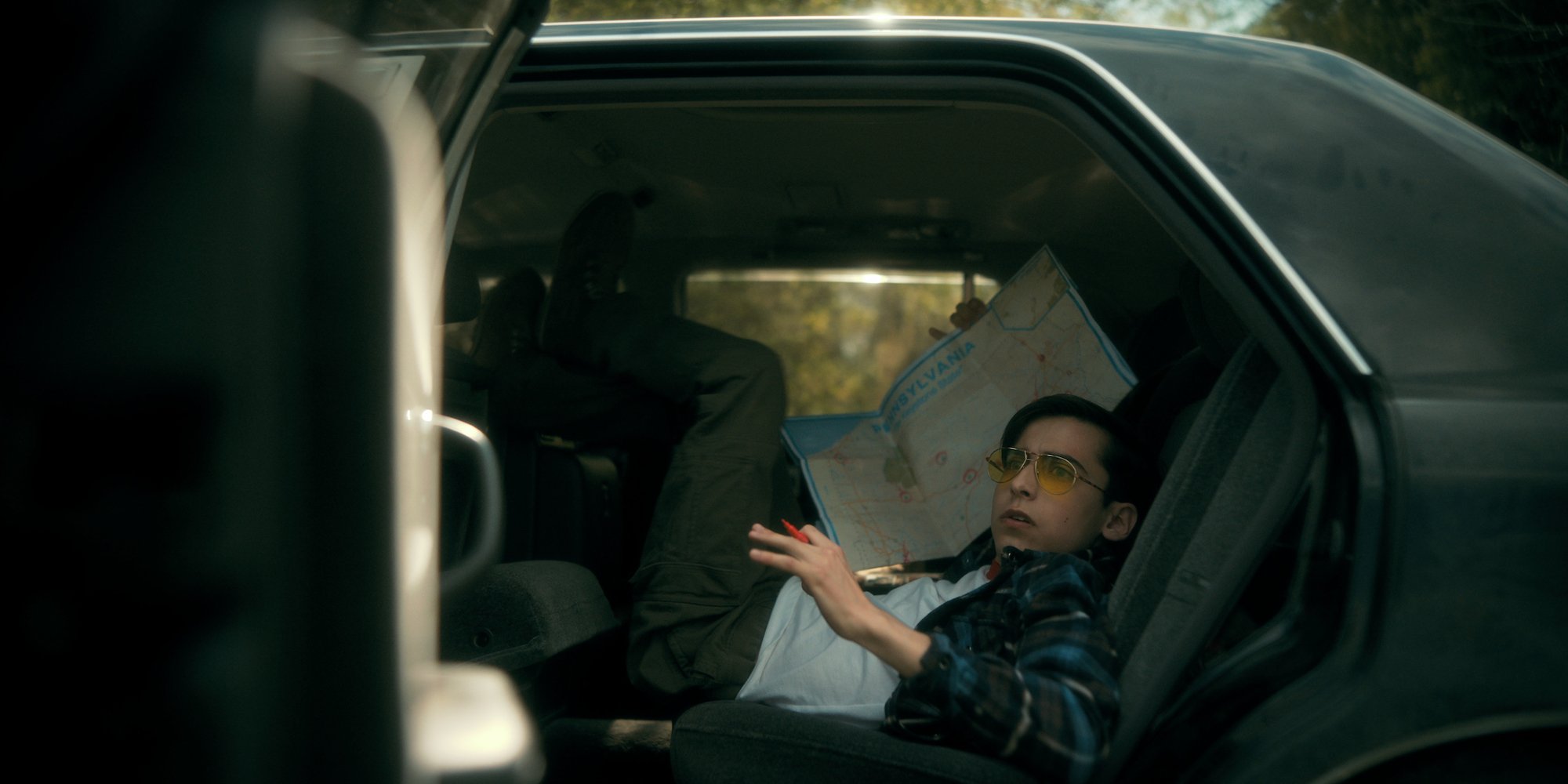 Aiden Gallagher as Number Five sitting in the back of a car in a production still. 'The Umbrella Academy' Season 3 full-length trailer arrives on May 19.