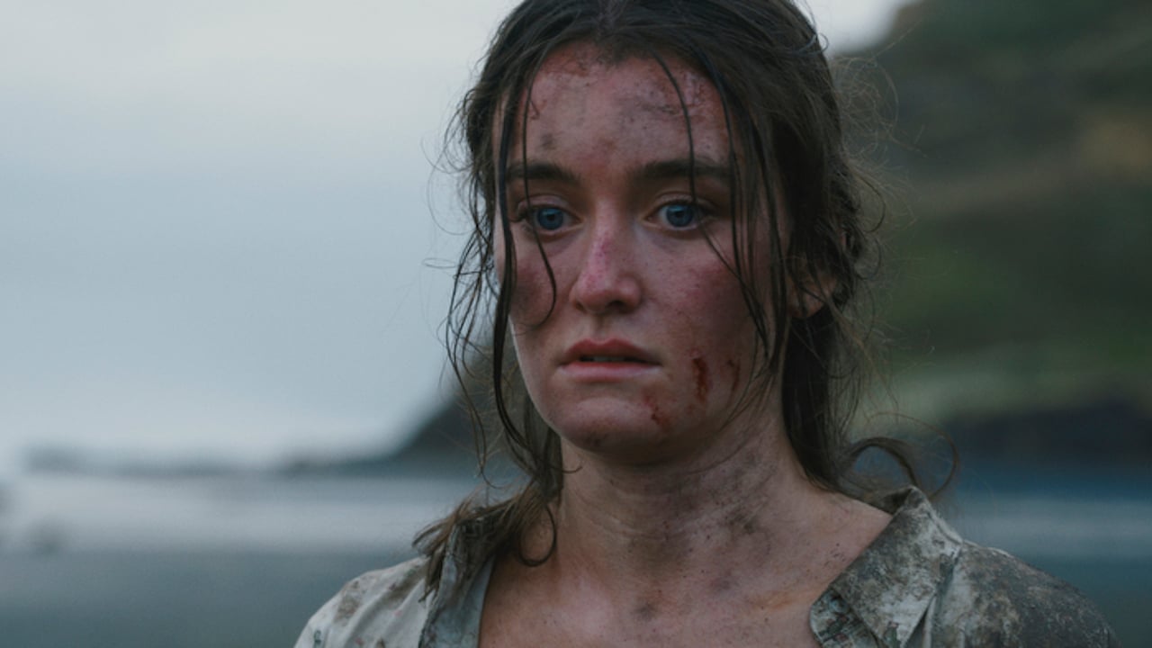 Sarah Pidgeon as Leah looks shocked and dirty on a beach on 'The Wilds'.