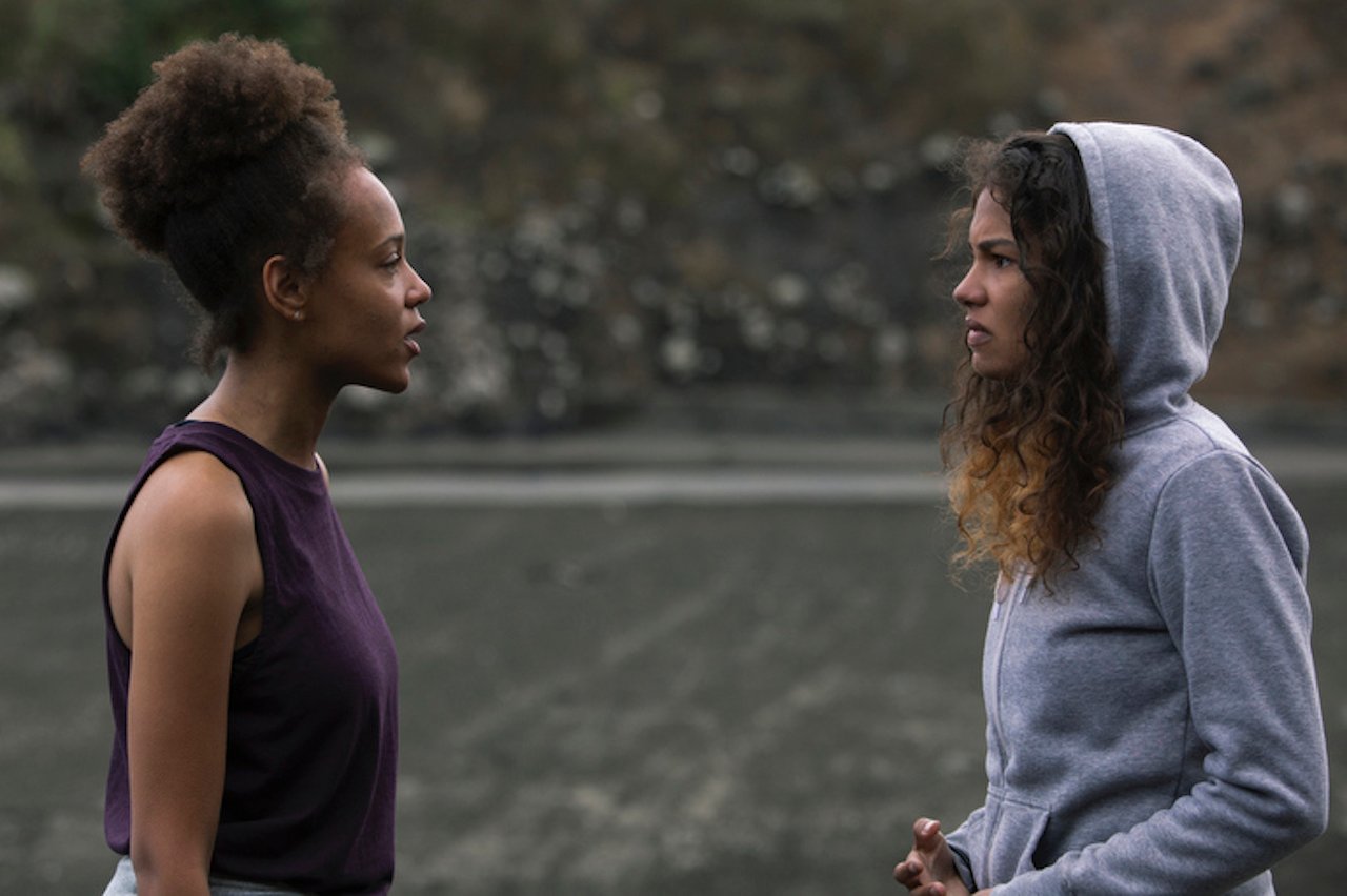 Reign Edwards as Rachel and Helena Howard as Nora talk to each other angrily on the beach in 'The Wilds'.