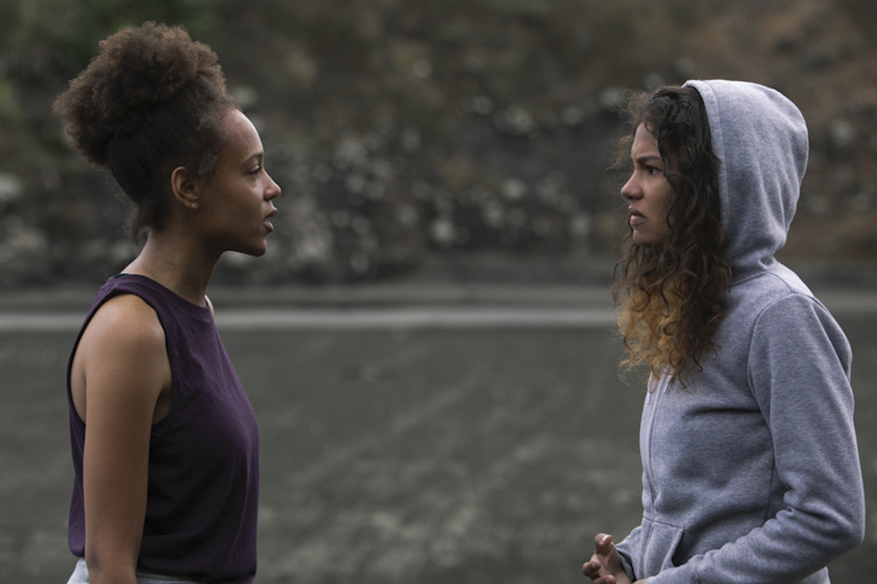 Reign Edwards as Rachel and Helena Howard as Nora talk to each other angrily on the beach in 'The Wilds'.