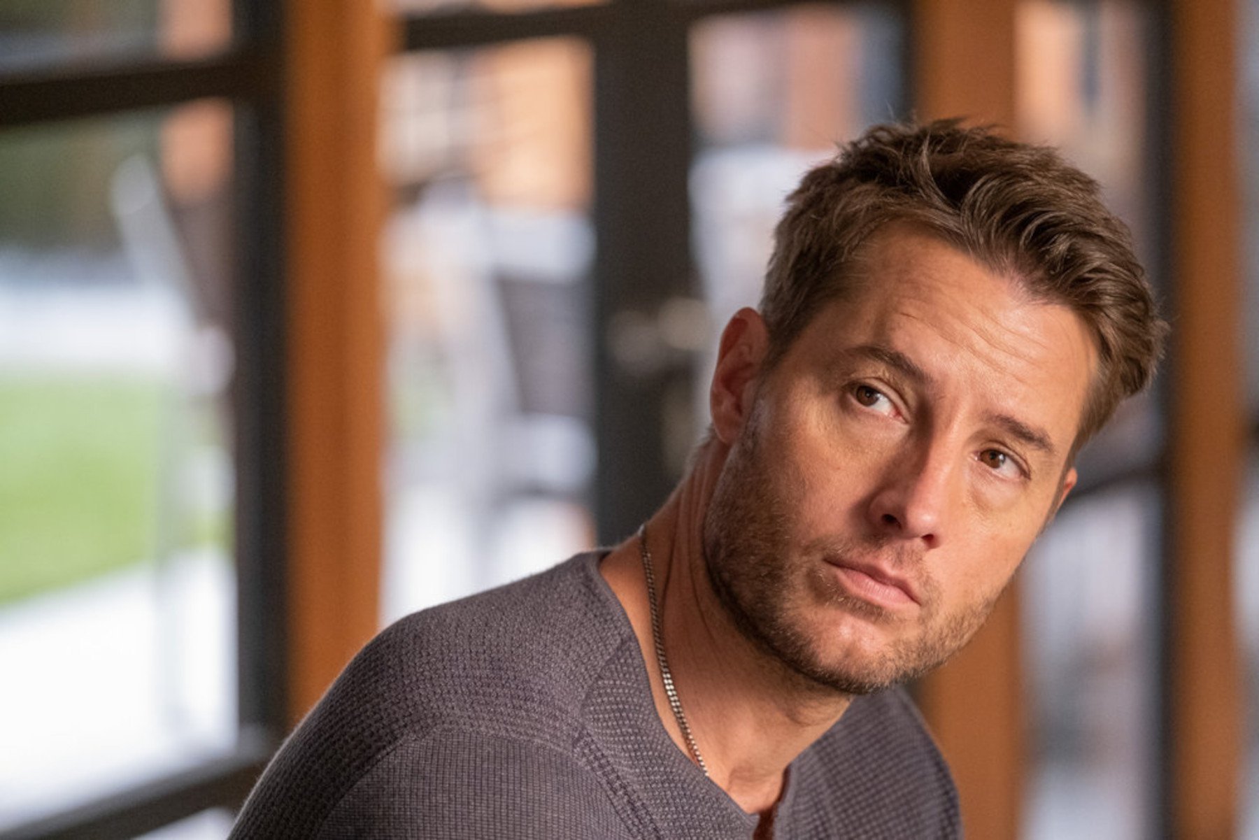 Justin Hartley as Kevin Pearson in 'This Is Us' Season 6 Episode 16. He's wearing a gray T-shirt and frowning.
